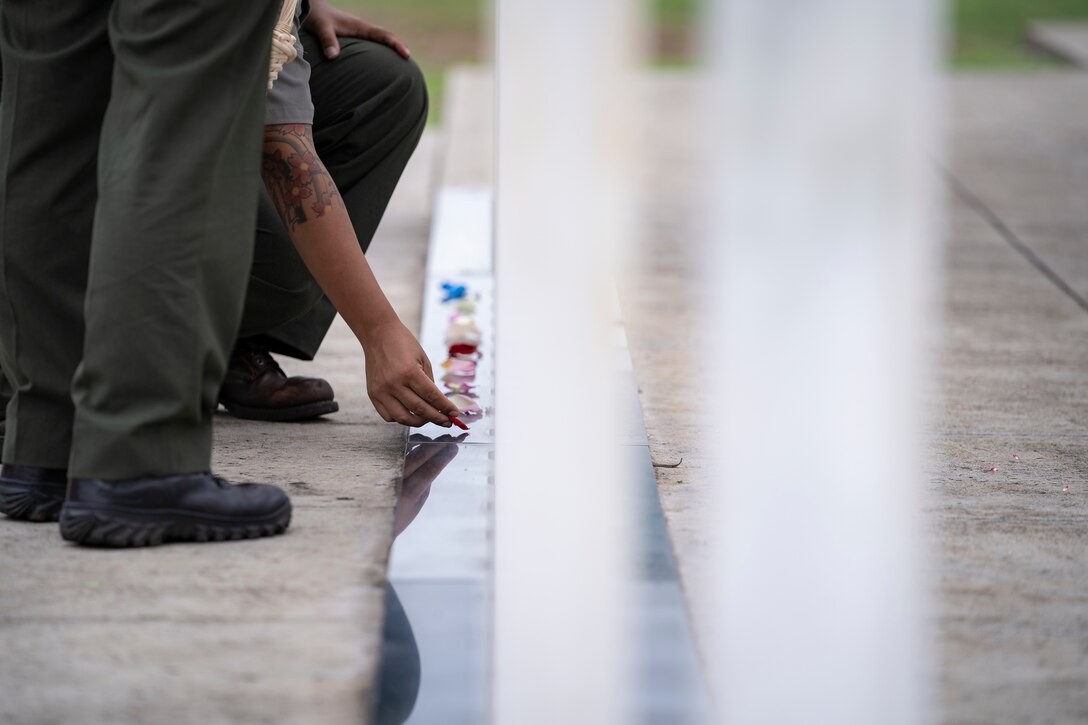 PEARL HARBOR, Hawaii (Dec. 7, 2021) - During the ceremony commemorating the 80th anniversary of the Japanese attack on Pearl Harbor, National Park Service Rangers lay rose petals on each memorial marker representing the 429 Sailors and Marines who lost their lives aboard the USS Oklahoma (BB-37). (U.S. Navy Photo by MC1 Jeffrey Hanshaw/Released).