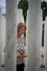 PEARL HARBOR, Hawaii (Dec. 7, 2021) - Carol Sowar waits to lay rose petals at a memorial marker for her uncles, Harold and William Trapp, two Sailors who died when the USS Oklahoma was torpedoed and sunk. Sowar, along with more than 200 visitors paid their respects to the fallen during the 2021 USS Oklahoma (BB-37) Memorial Ceremony which was held on the 80th anniversary of the Japanese attack on Pearl Harbor. Each of the 429 markers represents one Sailor or Marine killed during the attack.  (U.S. Navy Photo by MC1 Jeffrey Hanshaw/Released).