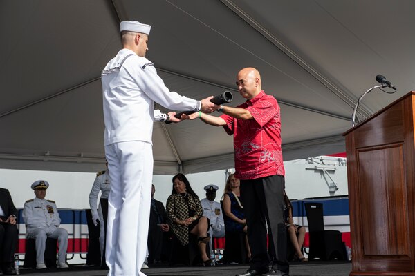 PEARL HARBOR, Hawaii (Dec. 8, 2021) Ken Inouye, son of the ship's namesake, delivers a long glass to the first watch team during the commissioning ceremony of USS Daniel Inouye (DDG 118). Homeported at Joint Base Pearl Harbor-Hickam, DDG 118 is the first U.S. Navy warship to honor the Honorable Daniel K. Inouye, a U.S. senator from Hawaii who served from 1962 until his death in 2012. During World War II, Inouye served in the U.S. Army’s 442nd Regimental Combat Team, one of the most decorated military units in U.S. history. For his combat heroism, which cost him his right arm, Inouye was awarded the Medal of Honor. (U.S. Navy photo by Mass Communication Specialist 1st Class Kelby Sanders)