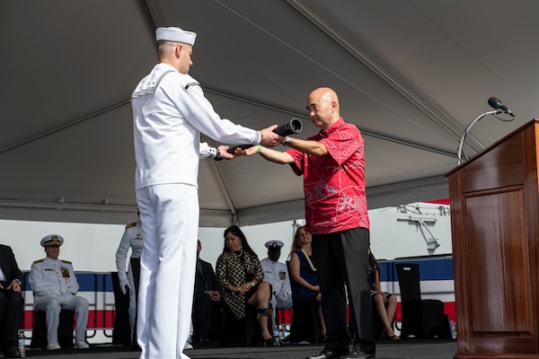 PEARL HARBOR, Hawaii (Dec. 8, 2021) Ken Inouye, son of the ship's namesake, delivers a long glass to the first watch team during the commissioning ceremony of USS Daniel Inouye (DDG 118). Homeported at Joint Base Pearl Harbor-Hickam, DDG 118 is the first U.S. Navy warship to honor the Honorable Daniel K. Inouye, a U.S. senator from Hawaii who served from 1962 until his death in 2012. During World War II, Inouye served in the U.S. Army’s 442nd Regimental Combat Team, one of the most decorated military units in U.S. history. For his combat heroism, which cost him his right arm, Inouye was awarded the Medal of Honor. (U.S. Navy photo by Mass Communication Specialist 1st Class Kelby Sanders)
