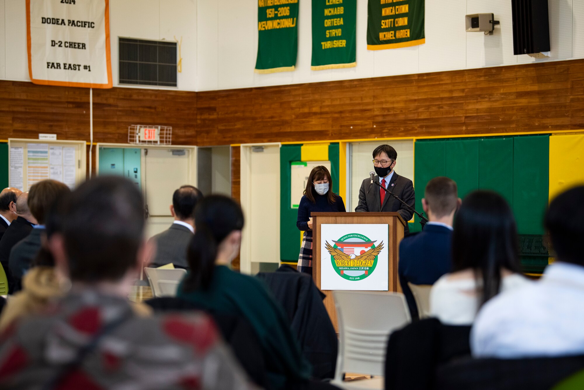 A government official speaks in front of a podium.