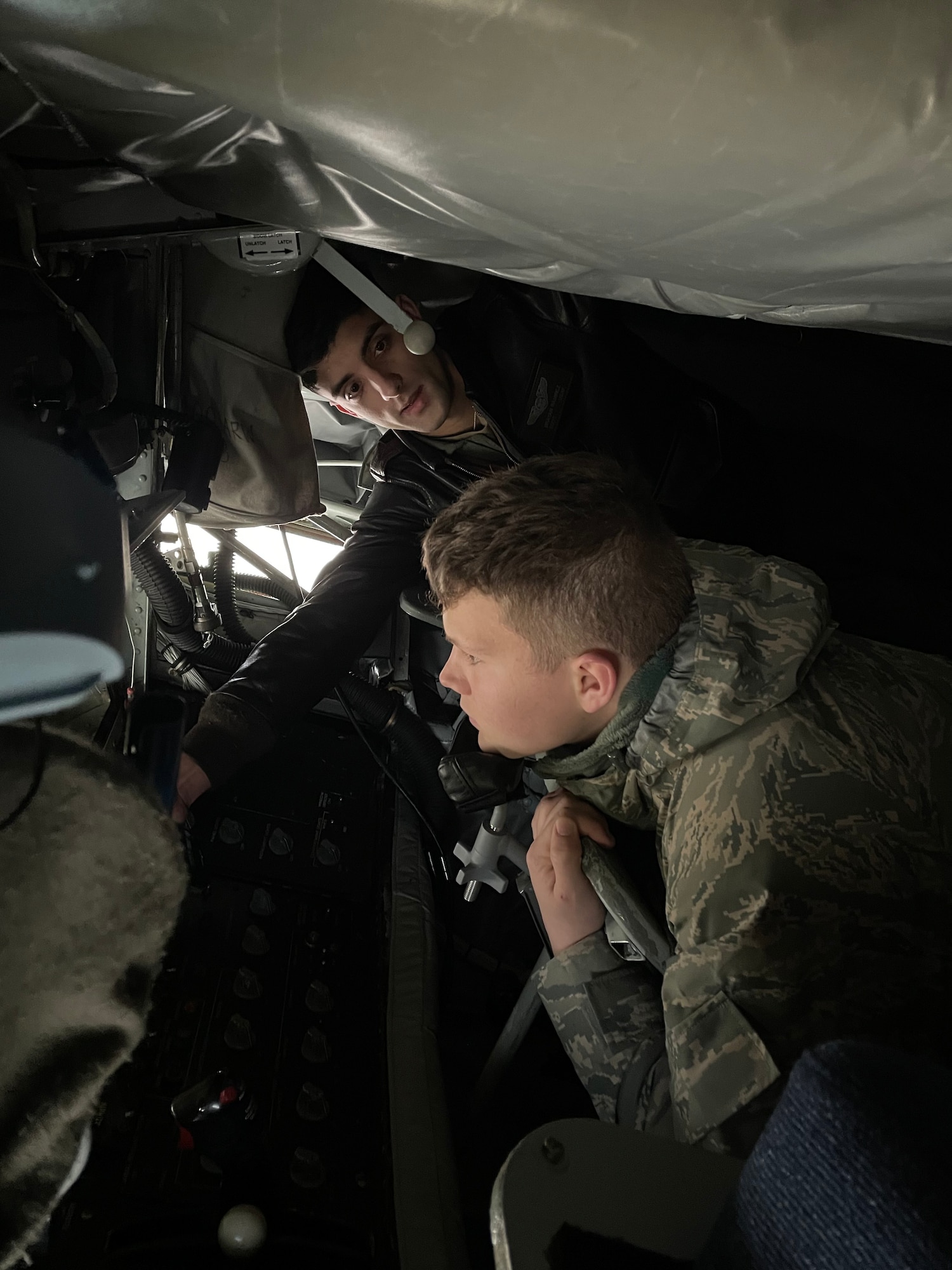 U.S. Air Force Staff Sgt. Brayan Ramirez, top, 351st Air Refueling Squadron boom operator, teaches a Mildenhall Squadron cadet about the boom pod of a KC-135 Stratotanker aircraft at Royal Air Force Mildenhall, England, Dec. 8, 2021. The cadets are part of the Civil Air Patrol cadet program and visited the base to tour a KC-135 static display. (U.S. Air Force photo by Senior Airman Joseph Barron)