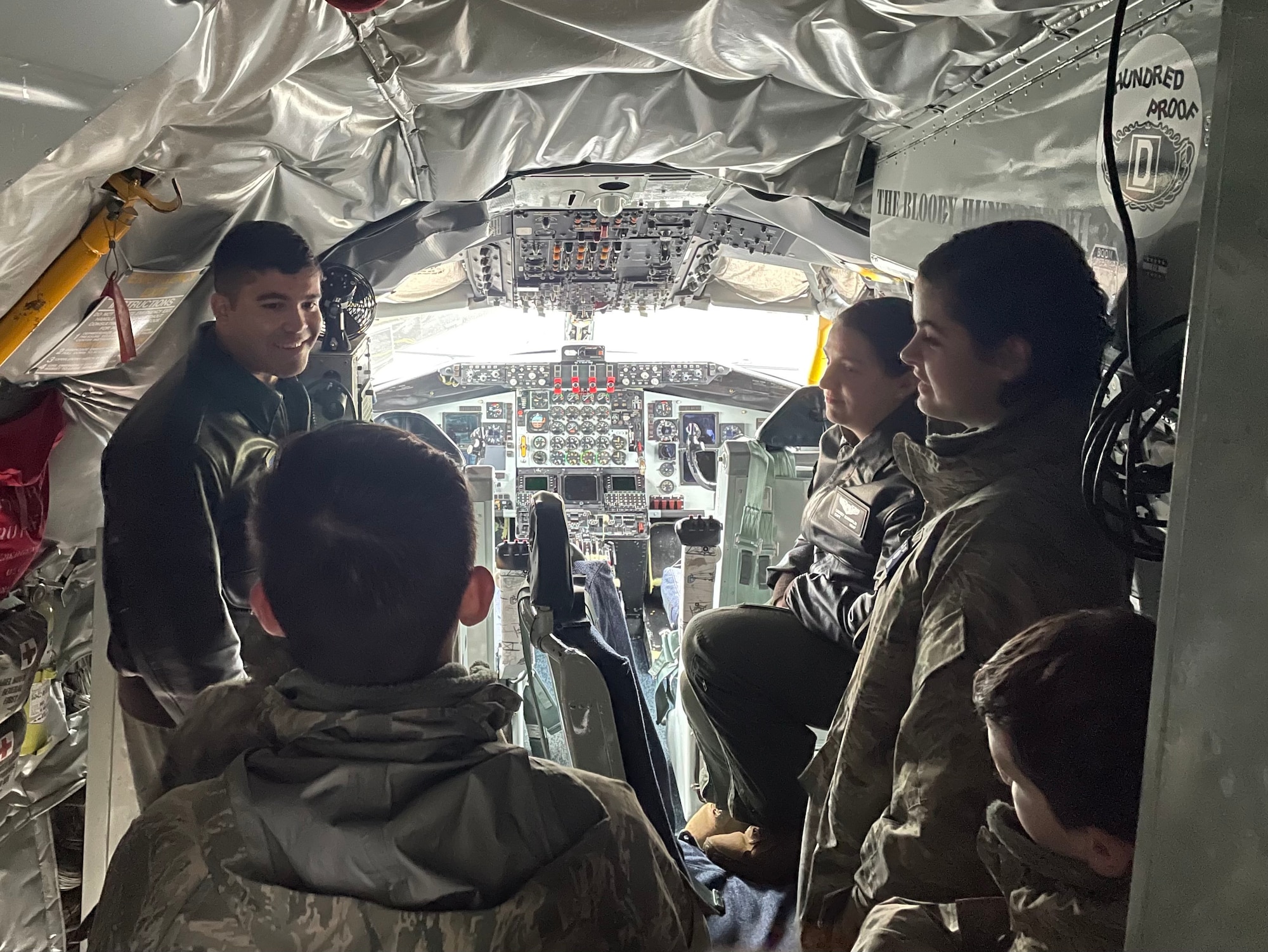 U.S. Air Force Airmen assigned to the 100th Air Refueling Wing discuss pilot training with members of the Mildenhall Cadet Squadron inside the cockpit of a KC-135 Stratotanker aircraft at Royal Air Force Mildenhall, England, Dec. 8, 2021. The cadets are part of the Civil Air Patrol cadet program and visited the base to tour a KC-135 static display. (U.S. Air Force photo by Senior Airman Joseph Barron)