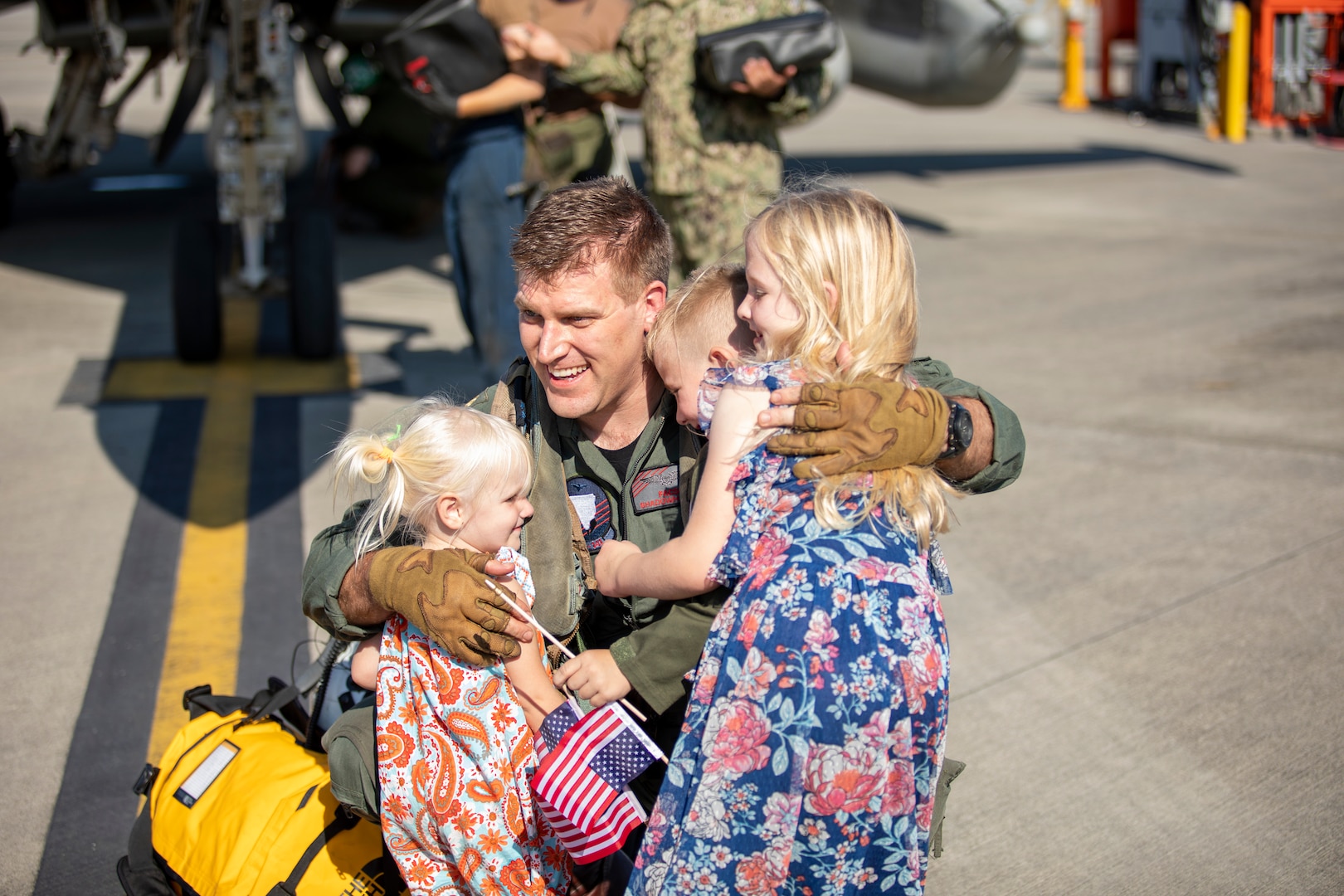 Service member hugs children