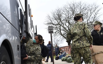 U.S. Navy Sailors load their bags onto a commercial bus outside of the Joint Readiness Center on Joint Base McGuire-Dix-Lakehurst, N.J., April 6, 2020. They are in transition from Joint Base McGuire-Dix-Lakehurst to New York City to help combat the spread of COVID-19. U.S Northern Command, through U.S. Army North is providing military Support to the Federal Emergency Management Agency to help communities in need. (U.S. Air Force photo by Staff Sgt. Jake Carter)