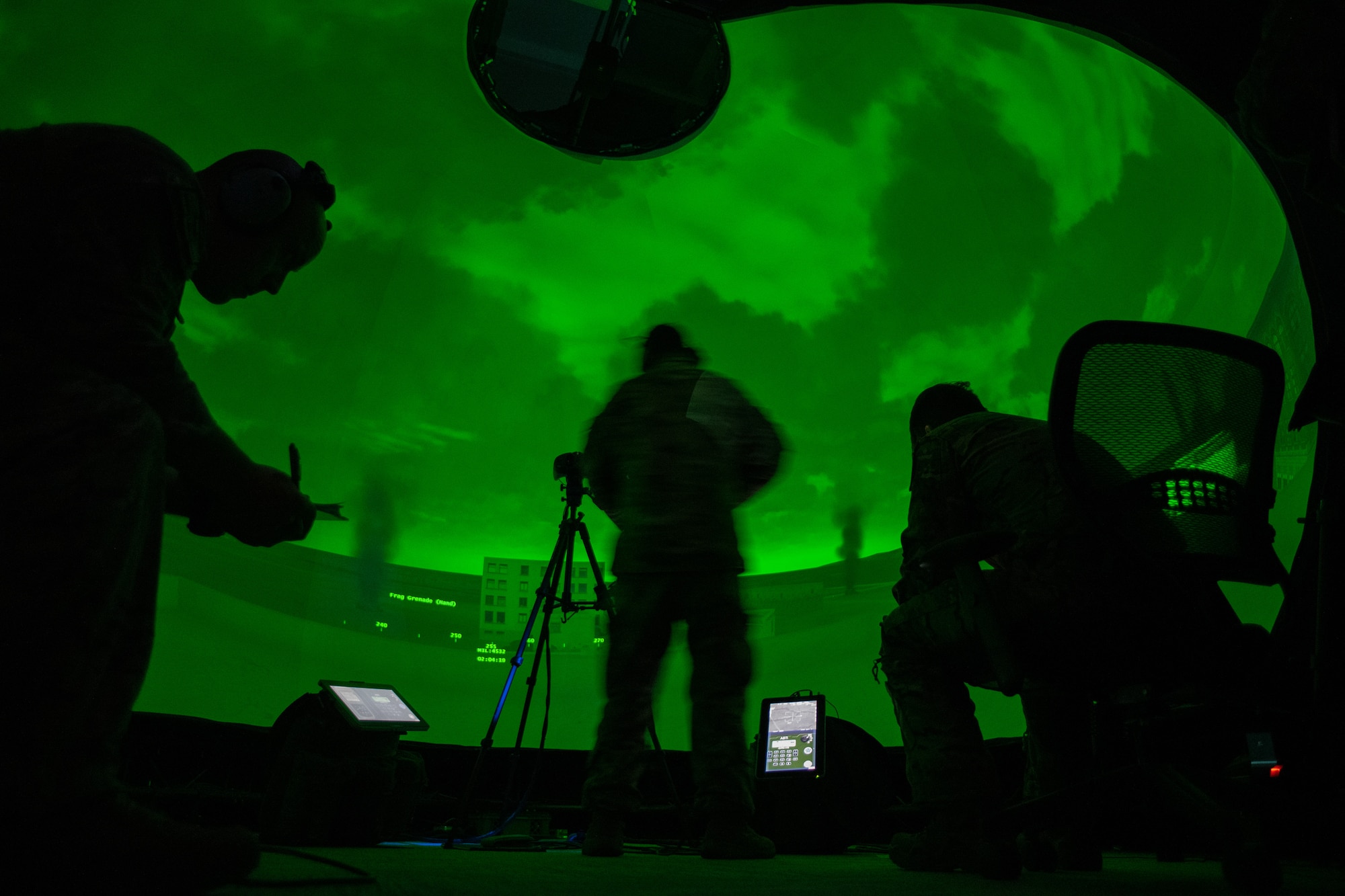 green simulator light illuminates three men