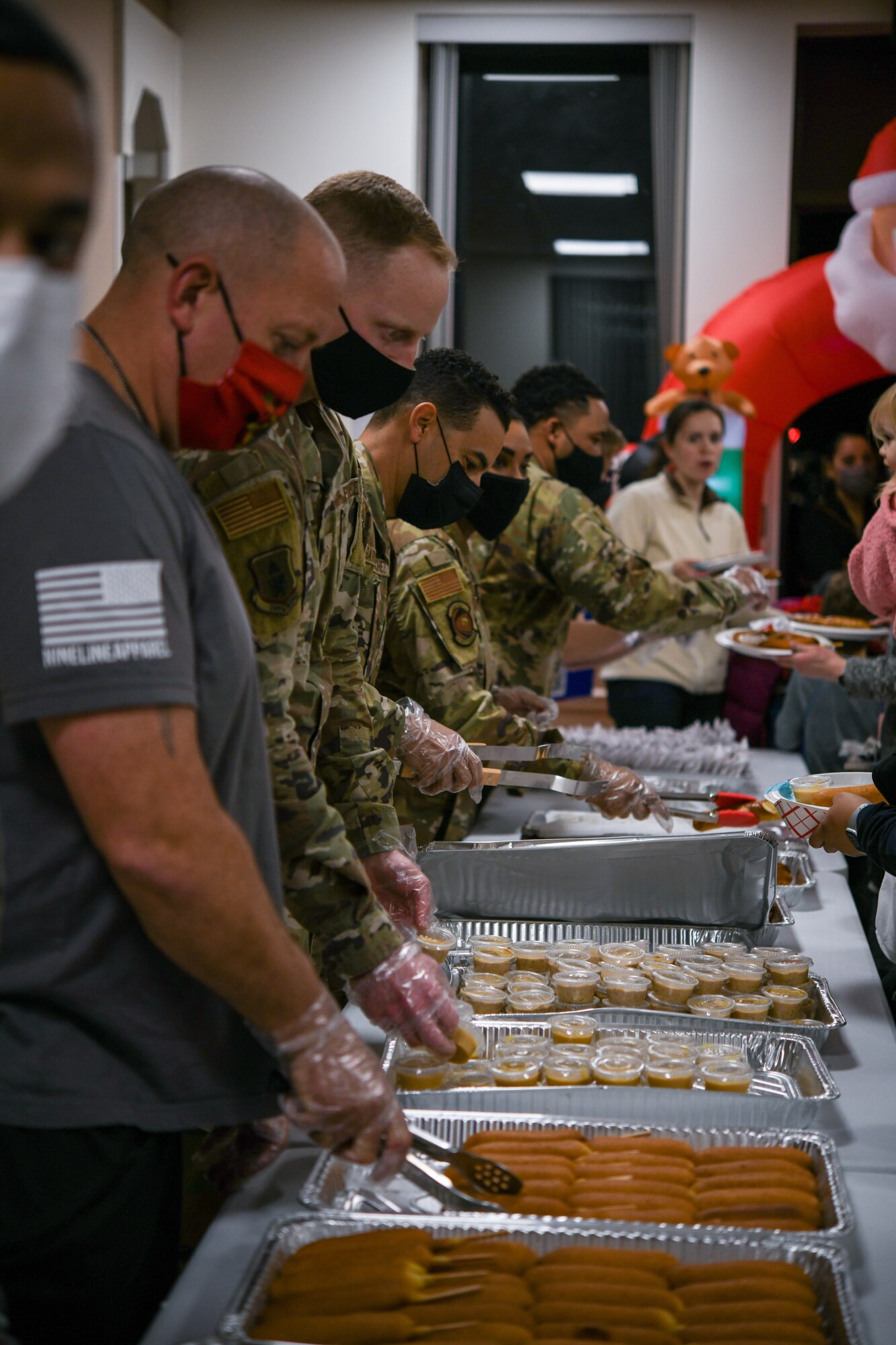 Joint Base Andrews first sergeants volunteer to serve food to all those attending the annual Holiday Extravaganza hosted by Chapel 1 at Joint Base Andrews, Md., Dec. 2, 2021.
