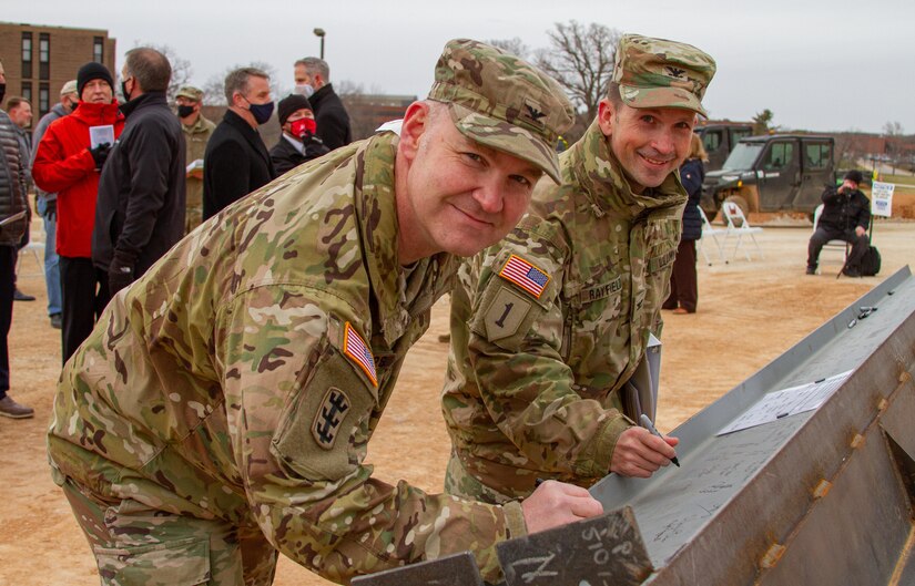 Northwestern Division Commander Col. Geoff Van Epps and Kansas City District Commander Col. Travis Rayfield sign the last piece of structural steel for the General Leonard Wood Community Hospital Project before a Topping Out Ceremony at Fort Leonard Wood on Dec. 7, 2021.