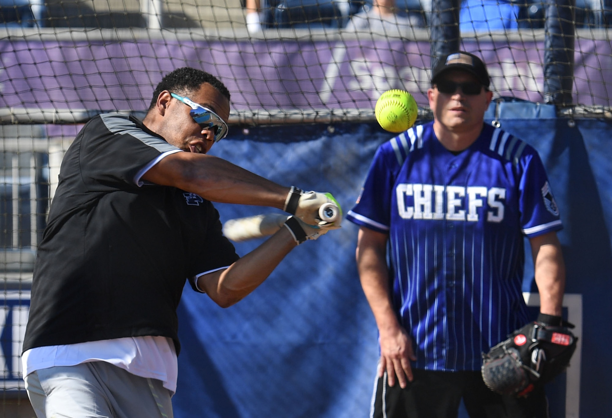 U.S. Air Force Maj. Justin Handley, 81st Communications Squadron commander, swings at a softball during the Chiefs vs. Eagles softball game at MGM Park in Biloxi, Mississippi, December 3, 2021. The chief master sergeants and colonels softball match, titled Chiefs vs. Eagles, was preceded by a homerun derby and a military working dog demonstration. (U.S. Air Force photo by Kemberly Groue)