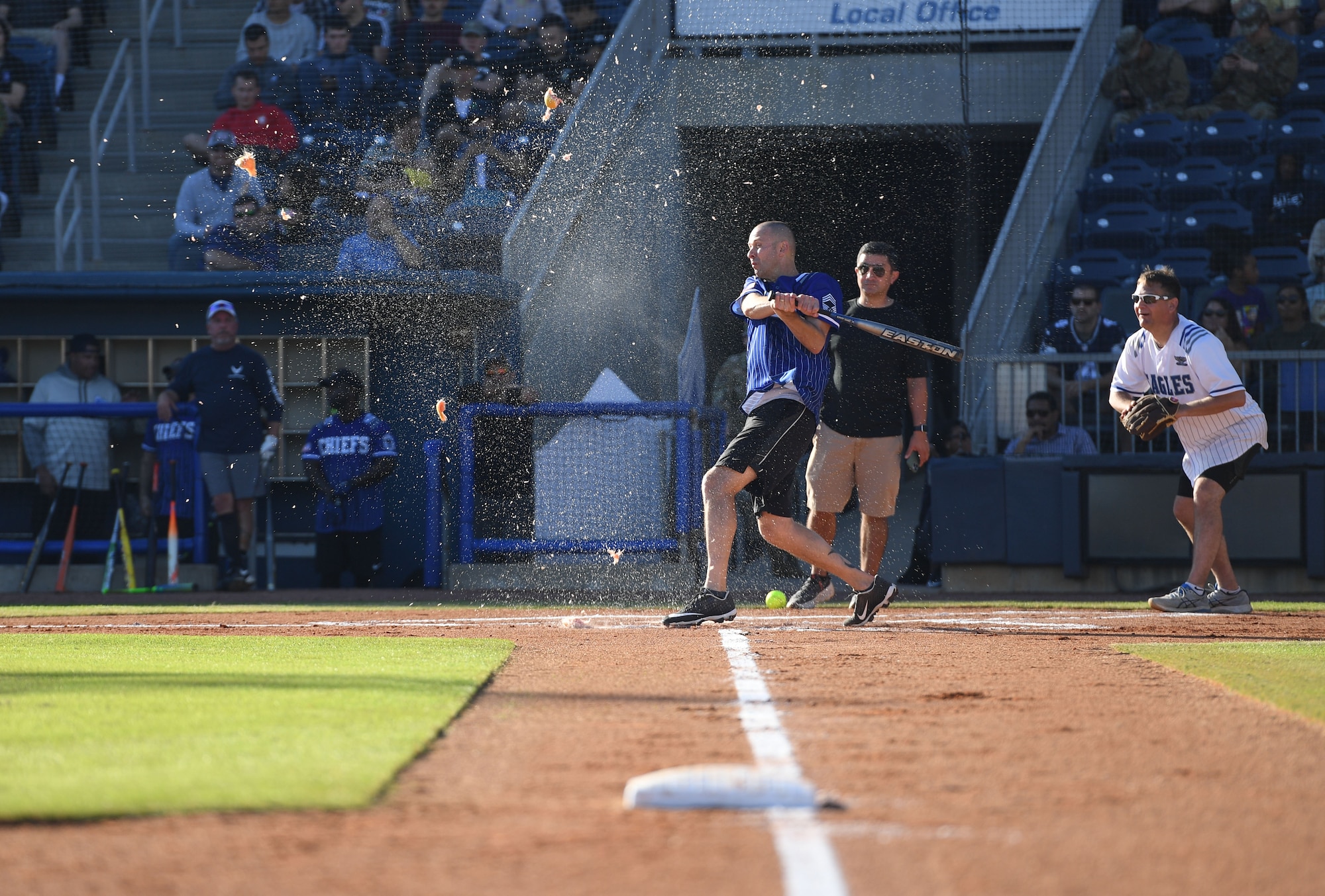 U.S. Air Force Chief Master Sgt. Lance Power, 81st Mission Support Group superintendent, smashes a grapefruit during the Chiefs vs. Eagles softball game at MGM Park in Biloxi, Mississippi, December 3, 2021. The chief master sergeants and colonels softball match, titled Chiefs vs. Eagles, was preceded by a homerun derby and a military working dog demonstration. (U.S. Air Force photo by Kemberly Groue)