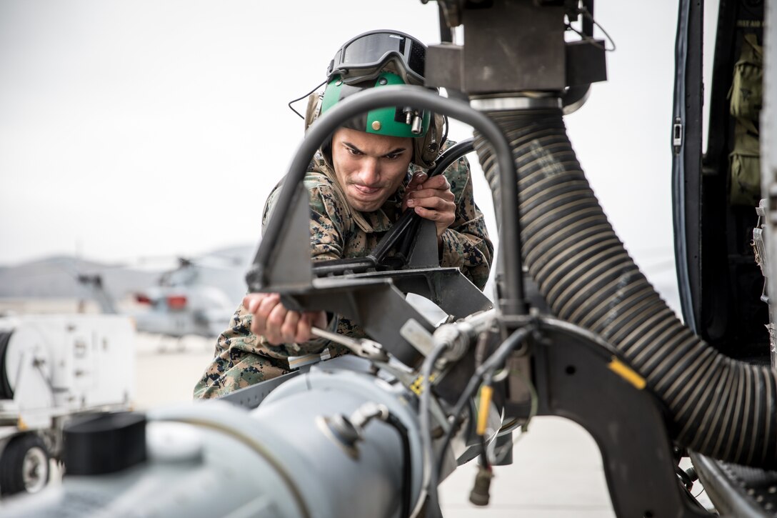 U.S. Marine Cpl. Kevin Morales, an aircraft avionics technician, U/AH-1, with Marine Light Attack Squadron 267, Marine Aircraft Group 39, 3rd Maine Aircraft Wing, connects the AN/ALQ-231(V)3 to a UH-1Y Venom on Marine Corps Air Station Camp Pendleton, Calif., Dec. 3 2021. The AN/ALQ-231(V)3 enhances the airborne electronic warfare capability for fixed and rotary wing aircraft by maintaining a distributed and adaptable network to defend against current and future threats. (U.S. Marine Corps photo by Sgt. Samuel Ruiz)