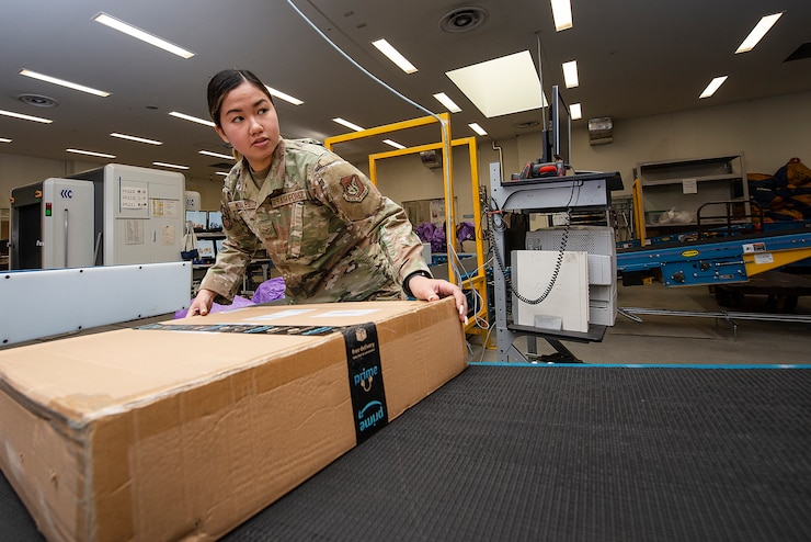 Airman 1st Class Precious Morales, Pacific Air Forces Air Postal Squadron mail processing clerk, moves packages down a conveyer belt for processing Dec. 3, 2021, at Yokota Air Base, Japan. The PACAF AIRPS can receive two to three times the amount of mail during the holiday season, and work seven days a week to ensure an increased flow of mail can be sorted and delivered across the region. Yokota Air Base’s geographical location makes it an ideal place for the PACAF AIRPS due to the installation’s close proximity to the squadron’s detachments, and ability to collaborate with two international airports.