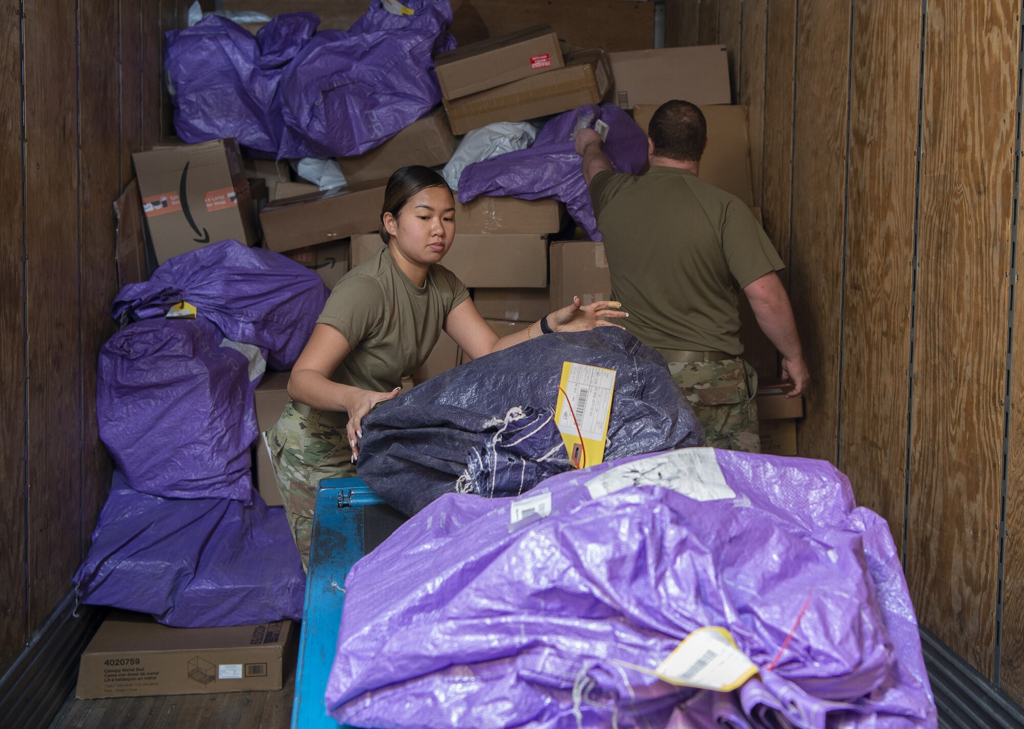 Airman 1st Class Precious Naomi Morales, left, and Staff Sgt. Derrick Stenstrom, Pacific Air Forces Air Postal Squadron mail processing clerks, sort mail Dec. 6, 2021, at Yokota Air Base, Japan. The PACAF AIRPS can receive two to three times the amount of mail during the holiday season, and work seven days a week to ensure an increased flow of mail can be sorted and delivered across the region. Yokota Air Base’s geographical location makes it an ideal place for the PACAF AIRPS due to the installation’s close proximity to the squadron’s detachments, and ability to collaborate with two international airports.