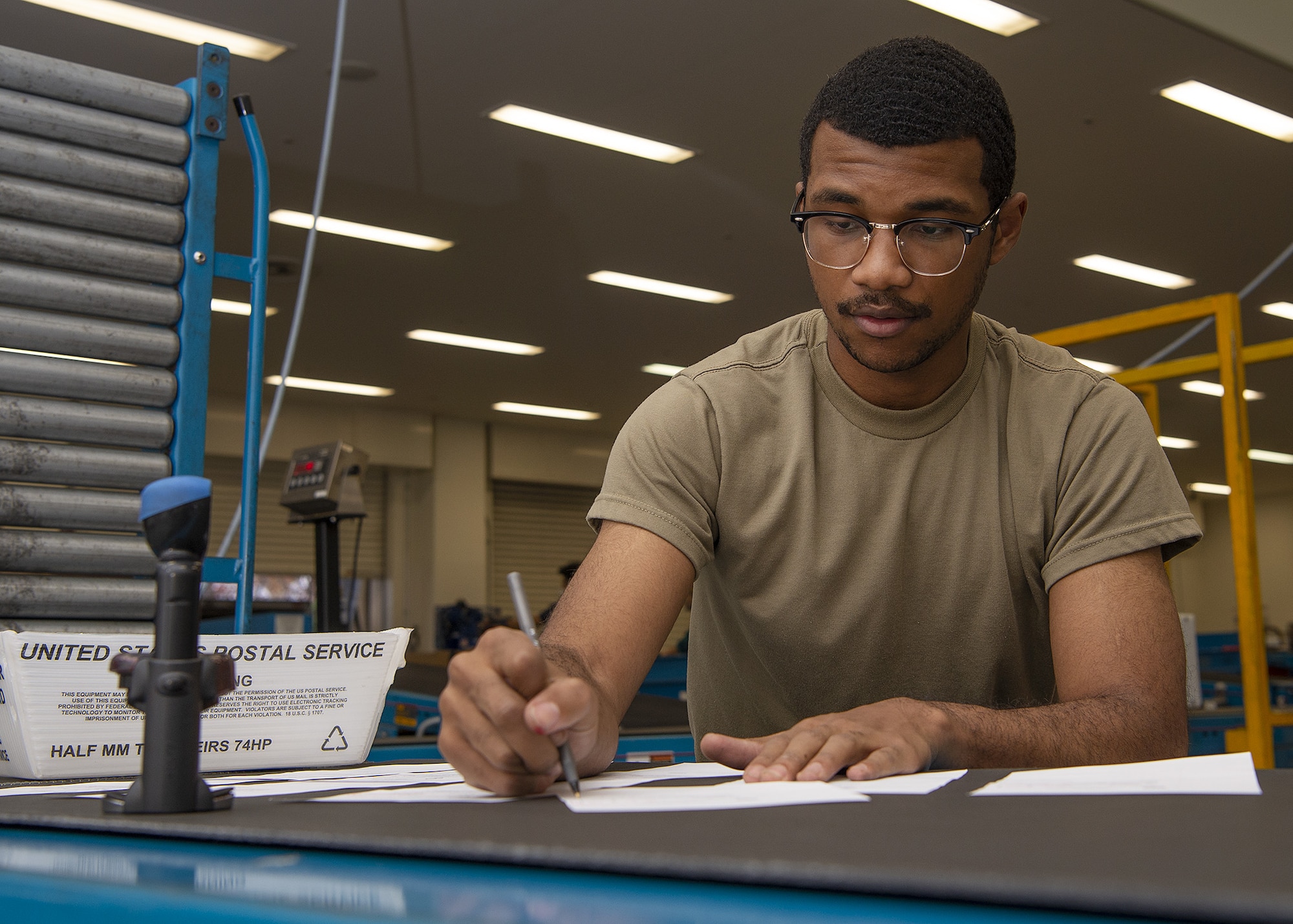 Airman 1st Class Najee Cain, Pacific Air Forces Air Postal Squadron mail processing clerk, prepares Japan Customs inspection memorandums Dec. 6, 2021, at Yokota Air Base, Japan. The PACAF AIRPS can receive two to three times the amount of mail during the holiday season, and work seven days a week to ensure an increased flow of mail can be sorted and delivered across the region. Yokota Air Base’s geographical location makes it an ideal place for the PACAF AIRPS due to the installation’s close proximity to the squadron’s detachments, and ability to collaborate with two international airports.