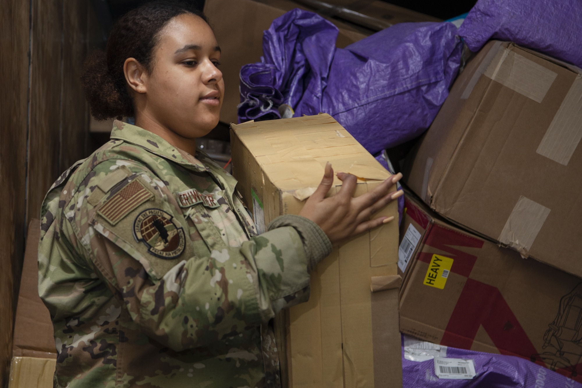 Airman 1st Class Sharia Meriweather, Pacific Air Forces Air Postal Squadron mail processing clerk, moves packages onto a conveyer belt as part of a mail sorting and inspection process Dec. 8, 2021, at Yokota Air Base, Japan. Members of the PACAF AIRPS transportation flight at Yokota Air Base integrate United States Postal Service and Government of Japan inspection policies into mail inspections for all mail destined for Yokota Air Base and Misawa Air Base. The squadron oversees operations for a transportation flight and 11 locations across the Pacific to serve more than 355,000 patrons across U.S. Indo-Pacific Command.