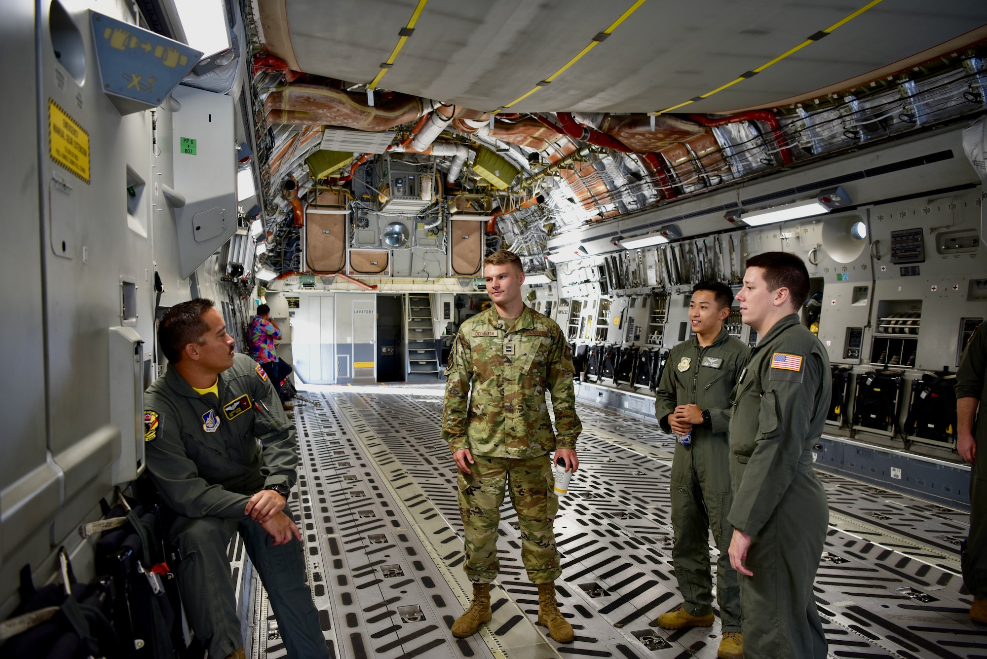 Senior Airman Samson Aina, 204th Airlift Squadron loadmaster, answers questions from cadets from the University of Hawaii Air Force Reserve Officer Training Corps during a base tour at Joint Base Pearl Harbor-Hickam, Hawaii, Dec. 3, 2021. More than 40 cadets toured a C-17 Globemaster III and a KC-135 Stratotanker, learning the purpose and mission of each airframe and the crew that operate them. (U.S. Air Force photo by 1st Lt. Benjamin Aronson)