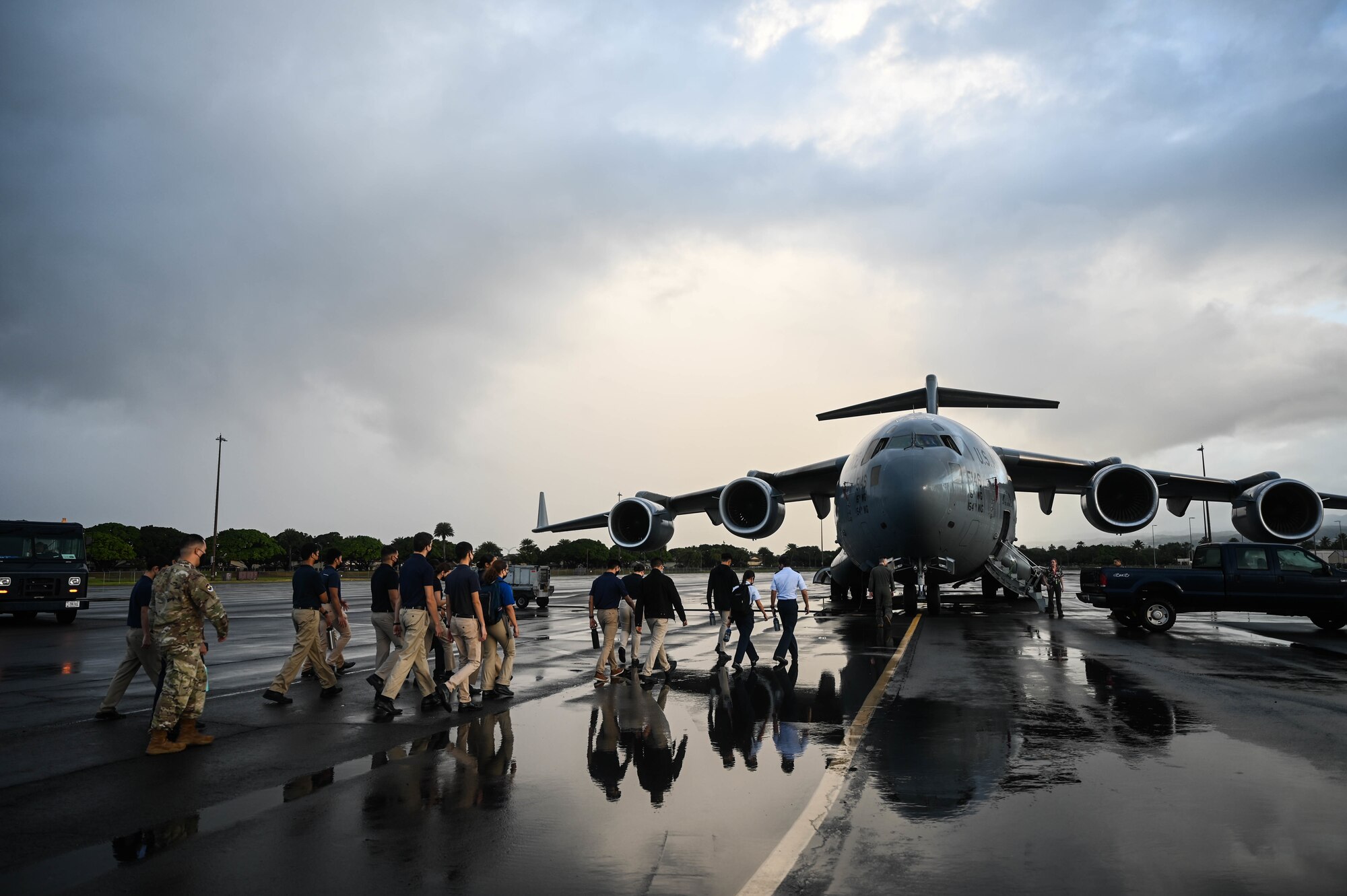 Cadets from the University of Hawaii Air Force Reserve Officer Training Corps approach a C-17 Globemaster III during a base tour at Joint Base Pearl Harbor-Hickam, Hawaii, Dec. 3, 2021. Active-duty Airmen and Guardsmen assigned to JBPHH familiarized more than 40 cadets with the C-17 and the KC-135 Stratotanker mission operations and capabilities. (U.S. Air Force photo by Staff Sgt. Alan Ricker)