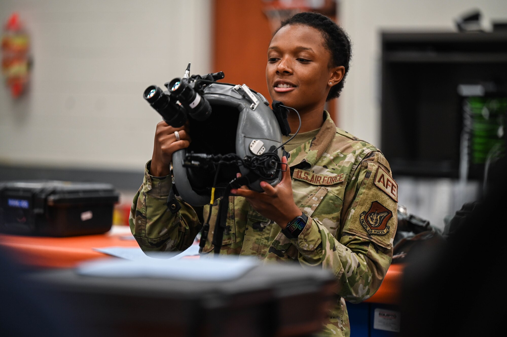 Airman 1st Class Kinnidi Warfield, 15th Operations Support Squadron aircrew flight equipment apprentice, demonstrates night vision goggles to University of Hawaii Air Force Reserve Officer Training Corps cadets during a base tour at Joint Base Pearl Harbor-Hickam, Hawaii, Dec. 3, 2021. Warfield and Airman 1st Class Coltin Zellmer, 15th OSS AFE apprentice, demonstrated the use of radios, NVGs, quick-don masks and other in-flight equipment while briefing groups of cadets. (U.S. Air Force photo by Staff Sgt. Alan Ricker)