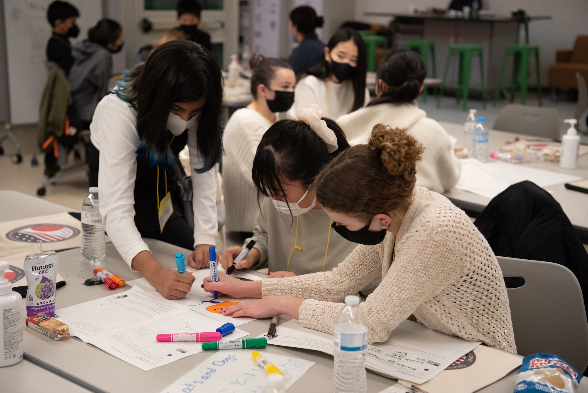 Students work on a project around a table.
