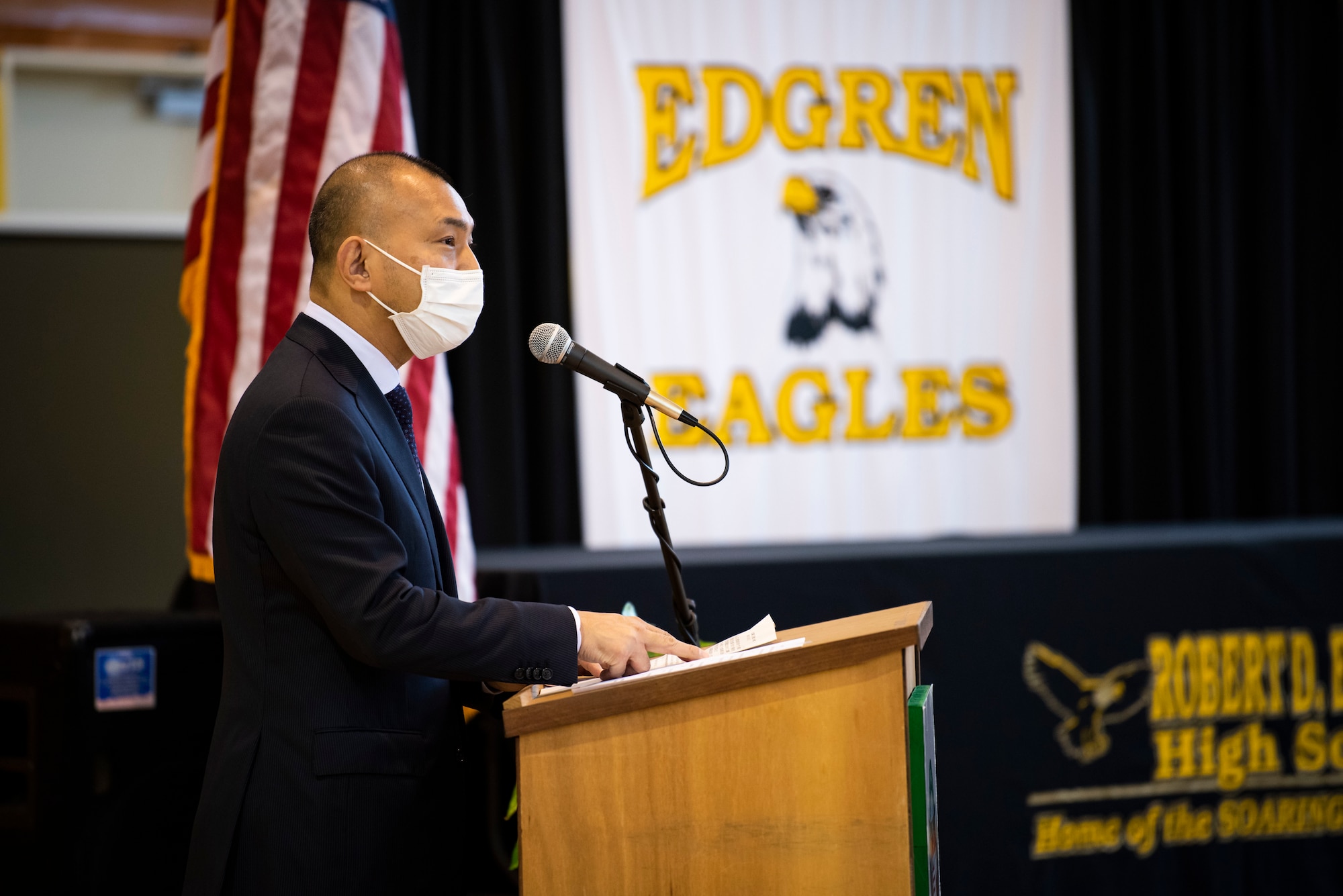 A government official speaks in front of a podium.