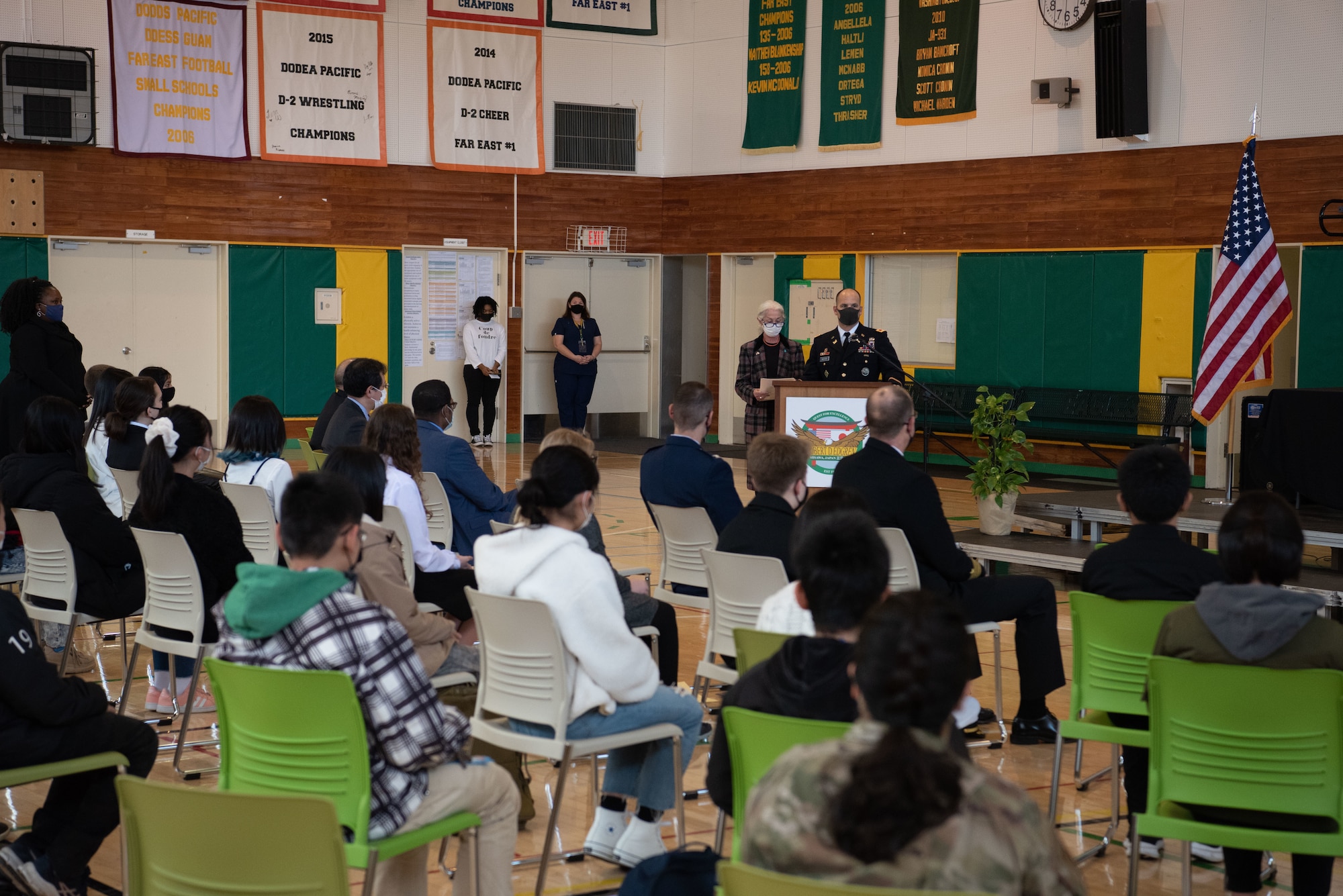 A military member speaks in front of a podium.