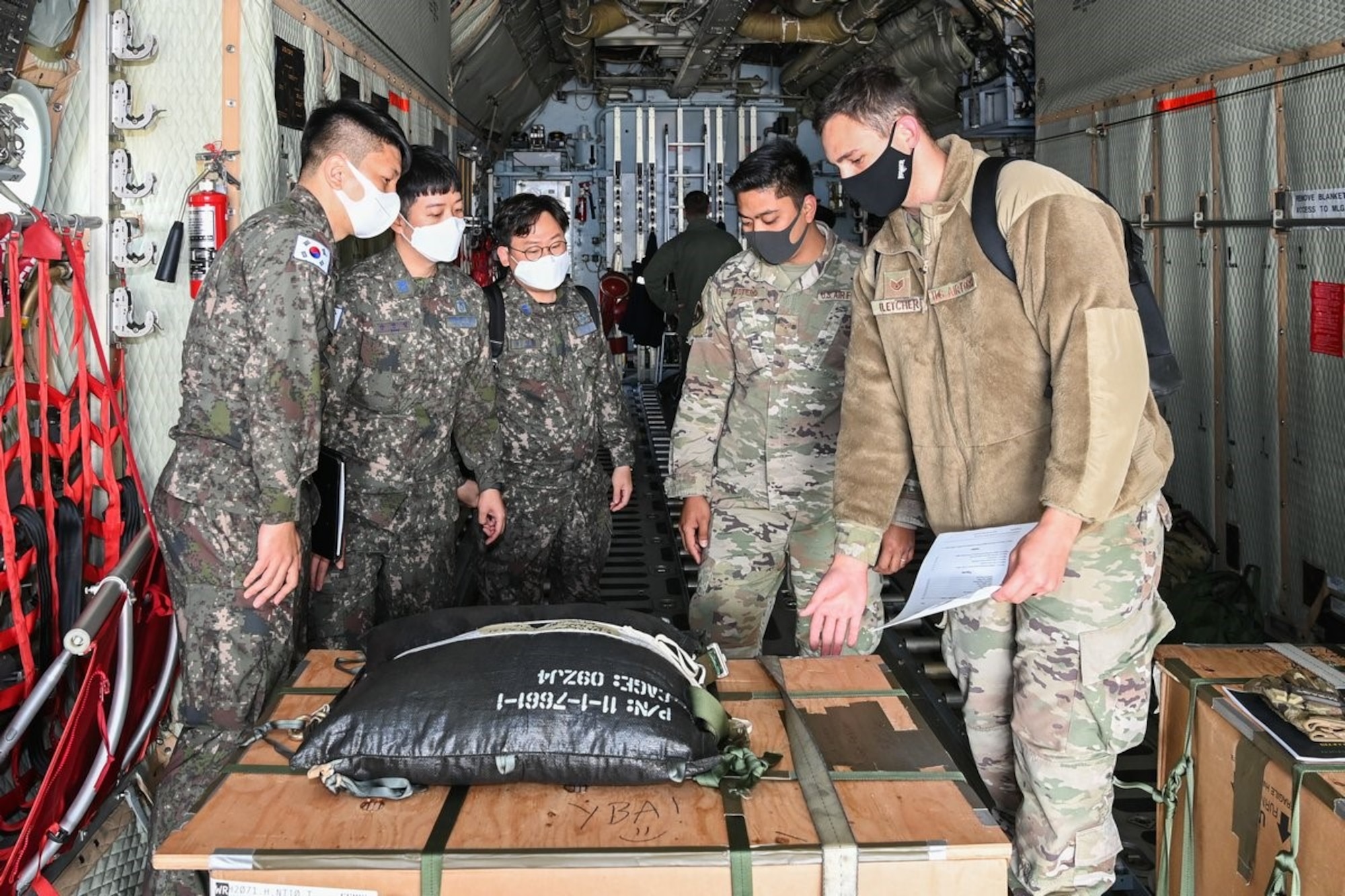 Republic of Korea and U.S. Air Force Airmen discuss air drops of palletized items for Operation Christmas Drop at Osan Air Base, Republic of Korea October 22, 2021. Each year, C-130 Hercules aircrews airdrop food, fishing equipment and clothing to more than 55 remote islands in the South-Eastern Pacific, including the Federated States of Micronesia and the Republic of Palau.  (Courtesy photo from Republic of Korea Air Force)