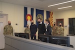 U.S. Air National Guard Lt. Col. Thomas Love, left, 112th Cyberspace Operations Squadron commander at Biddle Air National Guard Base in Horsham, Pennsylvania, escorts Lithuanian air force Col. Romualdas Petkevicius, front, right, director of the Regional Cyber Defence Center in Kaunas, Lithuania, during a tour of the 112th COS headquarters Dec. 6, 2021, to discuss capabilities, training and areas of future cooperation. Petkevicius was accompanied by, in order, to Petkevicius' right, Geistautas Cernius, chief of the cyber threat analysis cell at RCDC, and Mantas Bacevicius, computer systems engineer at the research and development division of the Lithuanian National Cyber Security Center. Badges in this photo were edited for security.