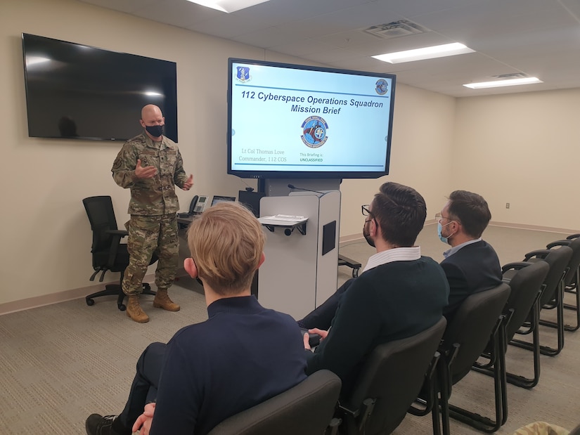 U.S. Army National Guard Maj. Christine Pierce (standing), Team Chief for the Pennsylvania Army National Guard’s Defensive Cyber Operations Element, briefs Lithuanian cyber defense representatives at Biddle Air National Guard Base in Horsham, Pennsylvania on December 6, 2021, about the DCOE Team mission and recent engagements with Pennsylvania’s State Partnership Program partner Lithuania.