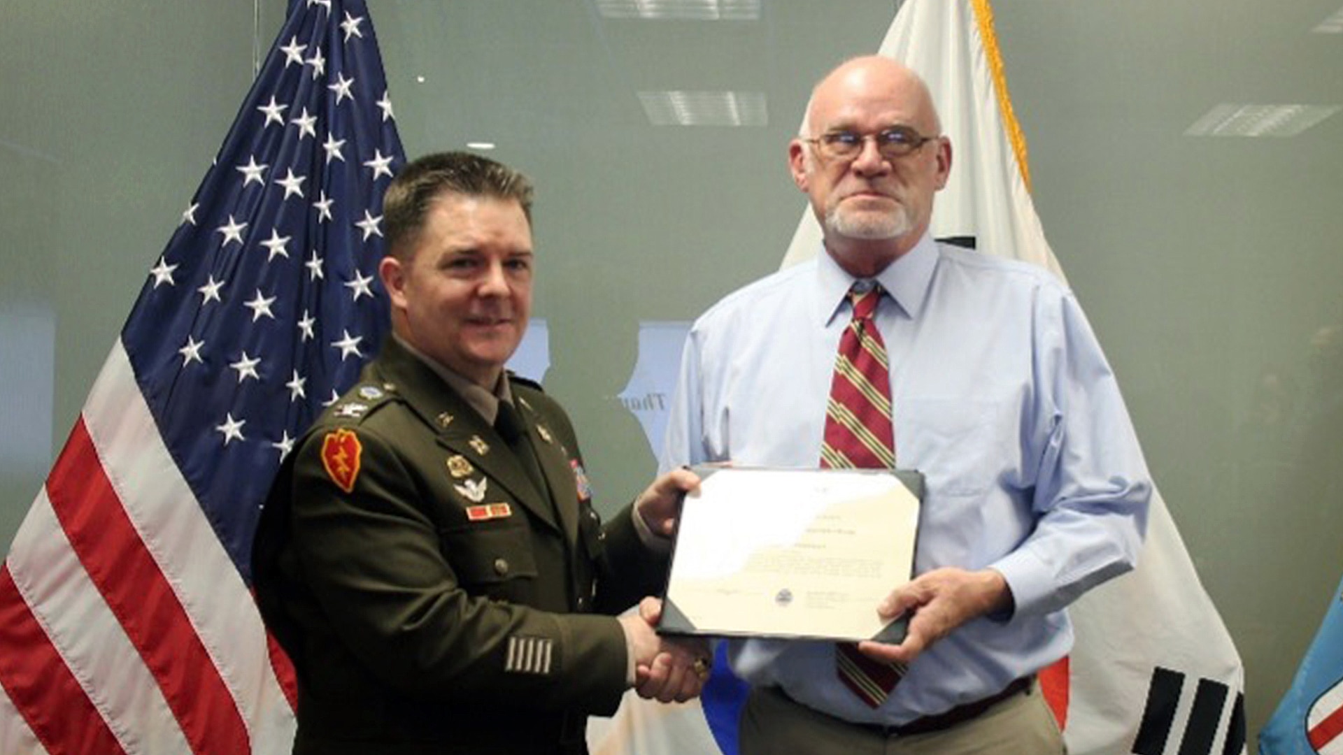 Commander presents an award to an employee.