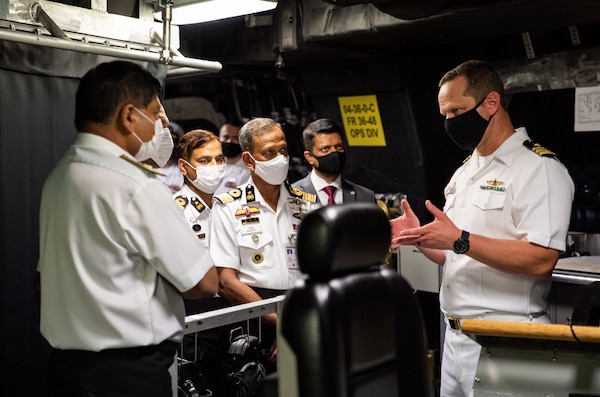 CHATTOGRAM, Bangladesh (Dec. 9, 2021) – Cmdr. Travis Dvorak, commanding officer of USS Tulsa (LCS 16), right, explains ship operations to Bangladesh Navy officers aboard the Independence-variant littoral combat ship during a reception for Cooperation Afloat Readiness and Training (CARAT) Bangladesh 2021. In its 27th year, CARAT series is comprised of multinational exercises, designed to enhance U.S. and partner navies’ abilities to operate together in response to traditional and non-traditional maritime security challenges in the Indo-Pacific region. Tulsa, part of Destroyer Squadron (DESRON) 7, is on a rotational deployment, operating in the U.S. 7th Fleet area of operations to enhance interoperability with partners and serve as a ready-response force in support of a free and open Indo-Pacific region. (U.S. Navy photo by Mass Communication Specialist 1st Class Devin M. Langer)