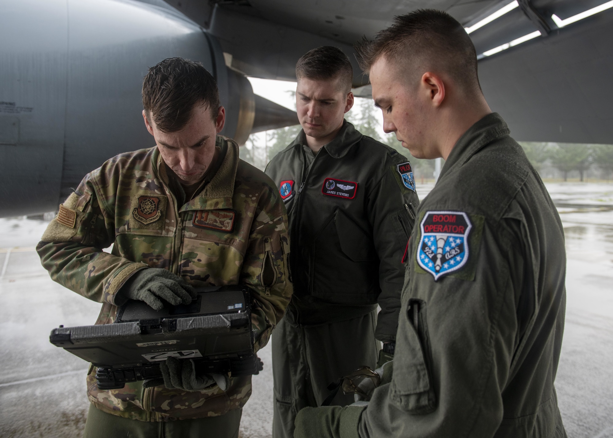 U.S. Air Force KC-135 Stratotanker aircrew members from Fairchild Air Force Base review technical orders on servicing a KC-135 during a large-scale readiness exercise at Joint Base Lewis-McChord, Washington, Dec. 7, 2021. Multiple crews from Fairchild flew to various locations to train and exercise multi-capable Airmen concepts, such as aircrew Airmen performing routine maintenance tasks on the KC-135. (U.S. Air Force photo by Staff Sgt. Lawrence Sena)