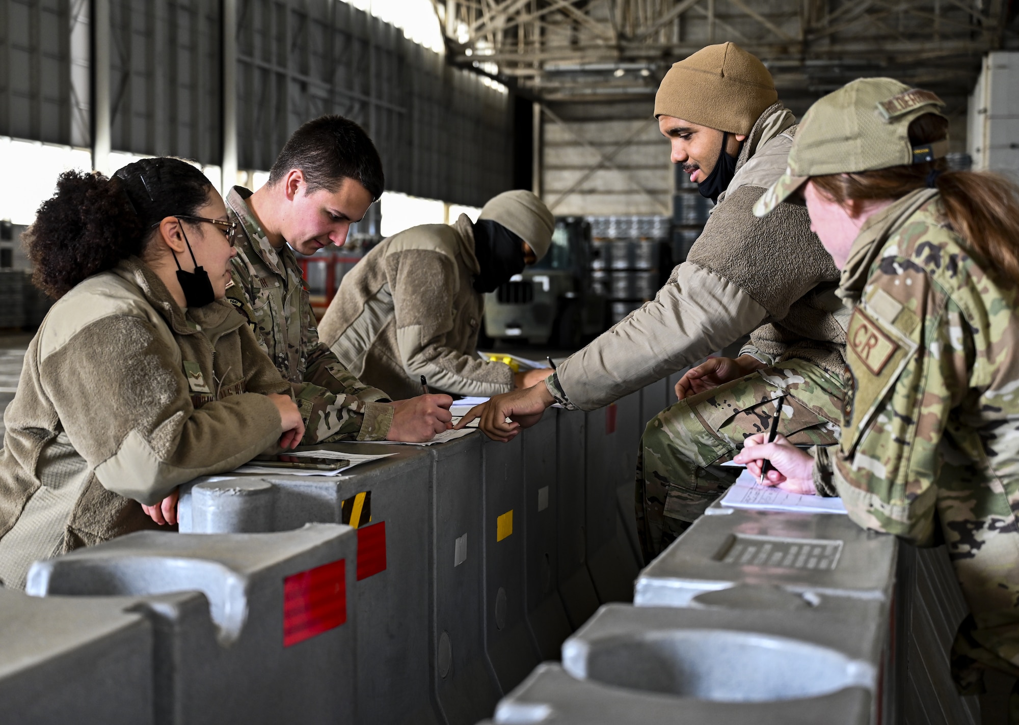 U.S. Air Force air transportation personnel with the 321st Contingency Response Squadron fill out joint inspection paperwork on Dec. 7, 2021, at Joint Base McGuire-Dix-Lakehurst, N.J. The 621st and 321st Contingency Response Squadrons along with the 6th Airlift Squadron and U.S. Army C5ISR Ground Activity, participated in a joint service exercise. Joint inspection qualifications were accomplished by Airmen who uploaded two M1126 STRYKER vehicles onto a C-17 Globemaster III. The airframe with cargo then performed multiple touch-and-goes at Naval Support Activity Lakehurst before returning to McGuire Air Force Base.
