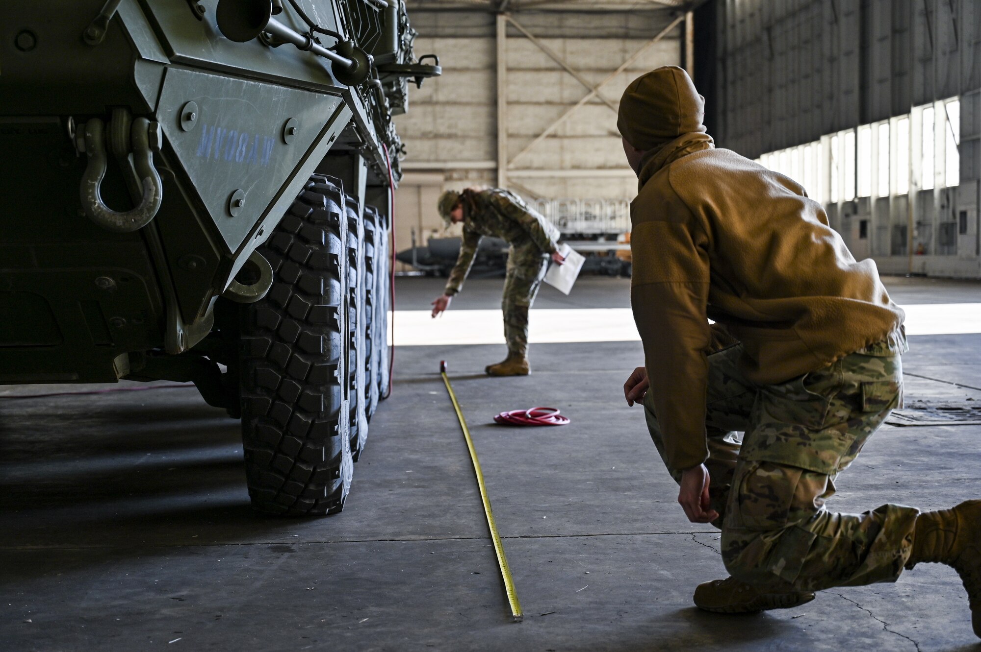 U.S. Air Force Staff Sgt. Jason Jones (front) and Airman 1st Class Reannah Hilderbrandt (back), 321st Contingency Response Squadron, air transportation specialists, measure the length of an M1126 STRYKER on Dec. 7, 2021, at Joint Base McGuire-Dix-Lakehurst, N.J. The 621st and 321st Contingency Response Squadrons along with the 6th Airlift Squadron and U.S. Army C5ISR Ground Activity, participated in a joint service exercise. Joint inspection qualifications were accomplished by Airmen who uploaded two M1126 STRYKER vehicles onto a C-17 Globemaster III. The airframe with cargo then performed multiple touch-and-goes at Naval Support Activity Lakehurst before returning to McGuire Air Force Base.