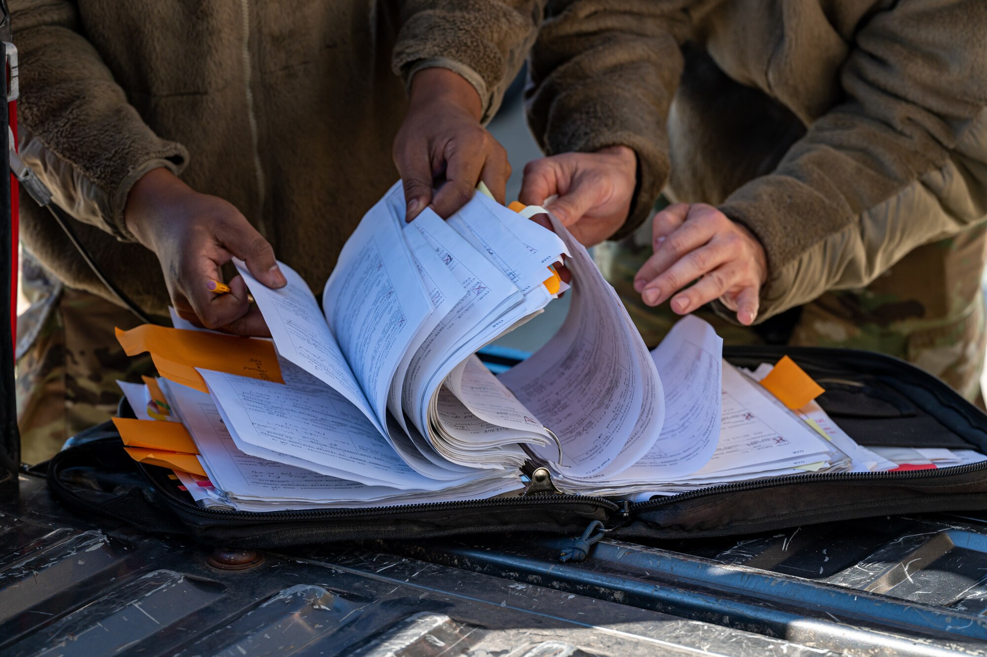 A photo of Airmen looking at a manual.