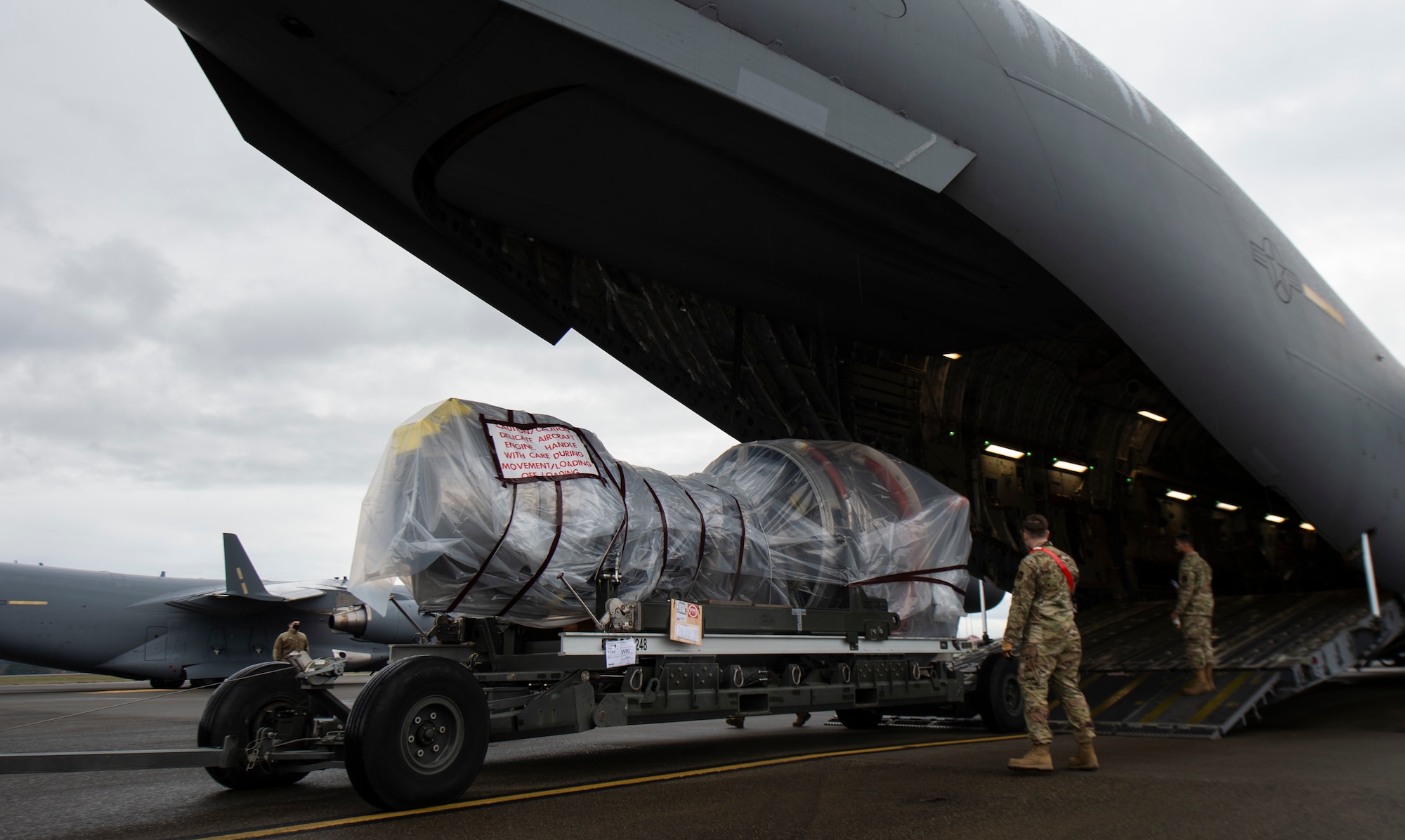 A C-17 Globemaster III jet engine is loaded onto a C-17 at Joint Base Lewis-McChord, Washington, Nov. 27, 2021. The jet engine was being delivered to Joint Base McGuire-Dix-Lakehurst, New Jersey, during the 816th Expeditionary Airlift Squadron deployment swap out at Al Udeid Air Base, Qatar. (U.S. Air Force photo by Staff Sgt. Tryphena Mayhugh)