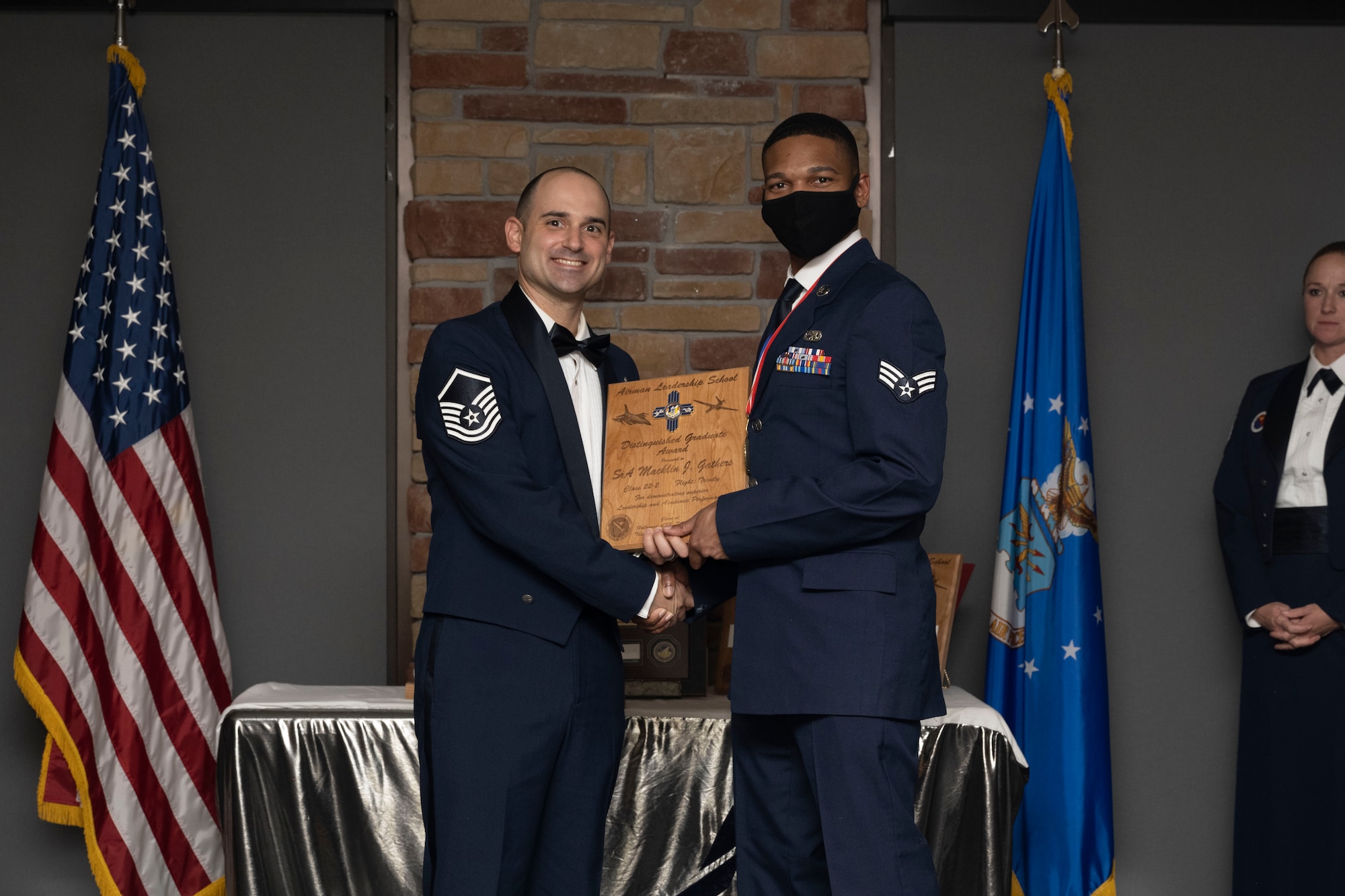 Senior Airman Macklin J. Gathers, Airman Leadership School graduate, accepts the distinguished graduate award during the graduation of ALS class 22-2, Dec. 9, 2021, on Holloman Air Force Base, New Mexico. The distinguished graduate award is presented to the top ten-percent of graduates for their performance in academic evaluations and demonstration of leadership. (U.S. Air Force photo by Senior Airman Kristin Weathersby)