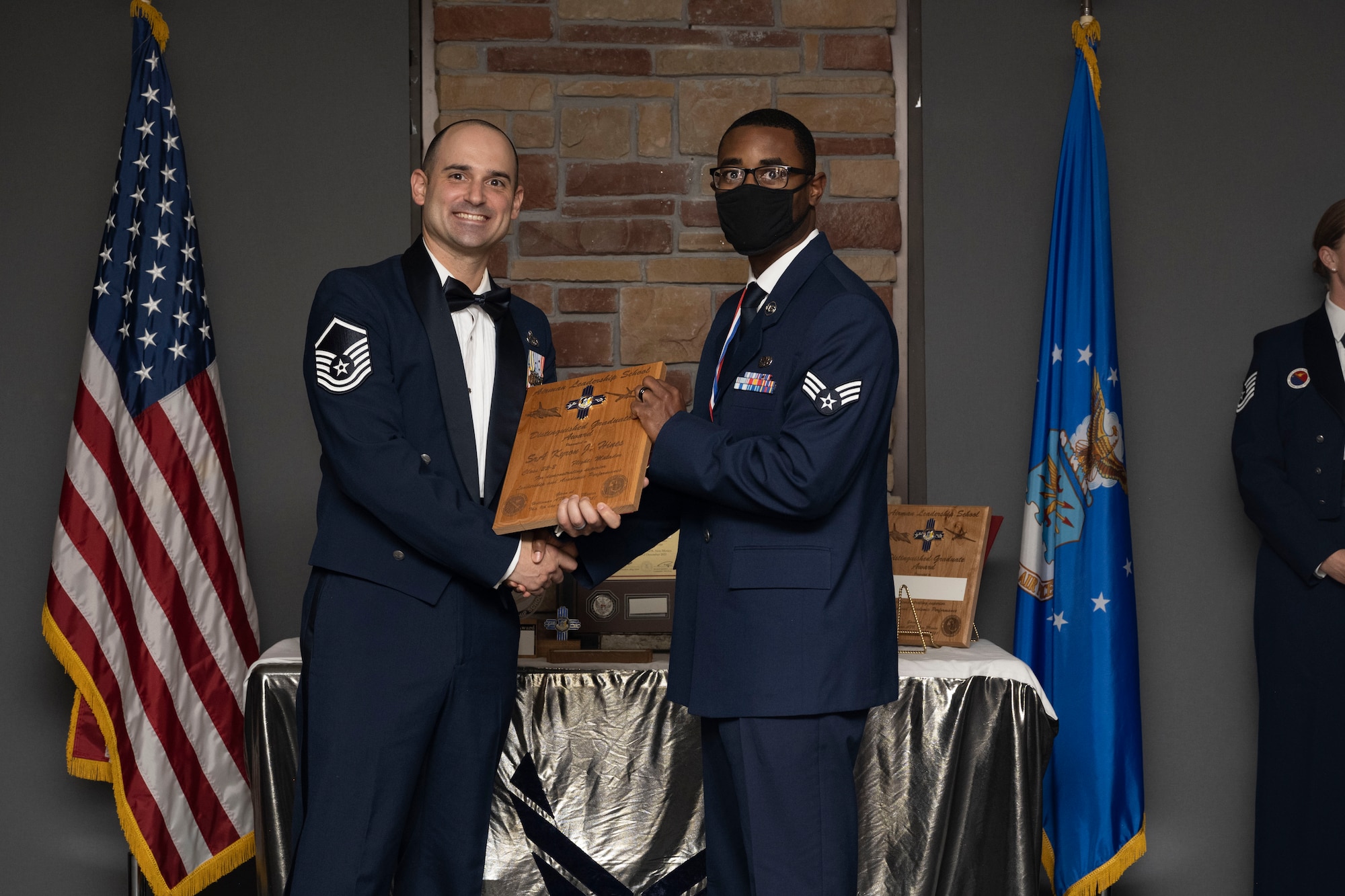 Senior Airman Kyron J. Hines, Airman Leadership School graduate, accepts the distinguished graduate award during the graduation of ALS class 22-2, Dec. 9, 2021, on Holloman Air Force Base, New Mexico. The distinguished graduate award is presented to the top ten-percent of graduates for their performance in academic evaluations and demonstration of leadership. (U.S. Air Force photo by Senior Airman Kristin Weathersby)