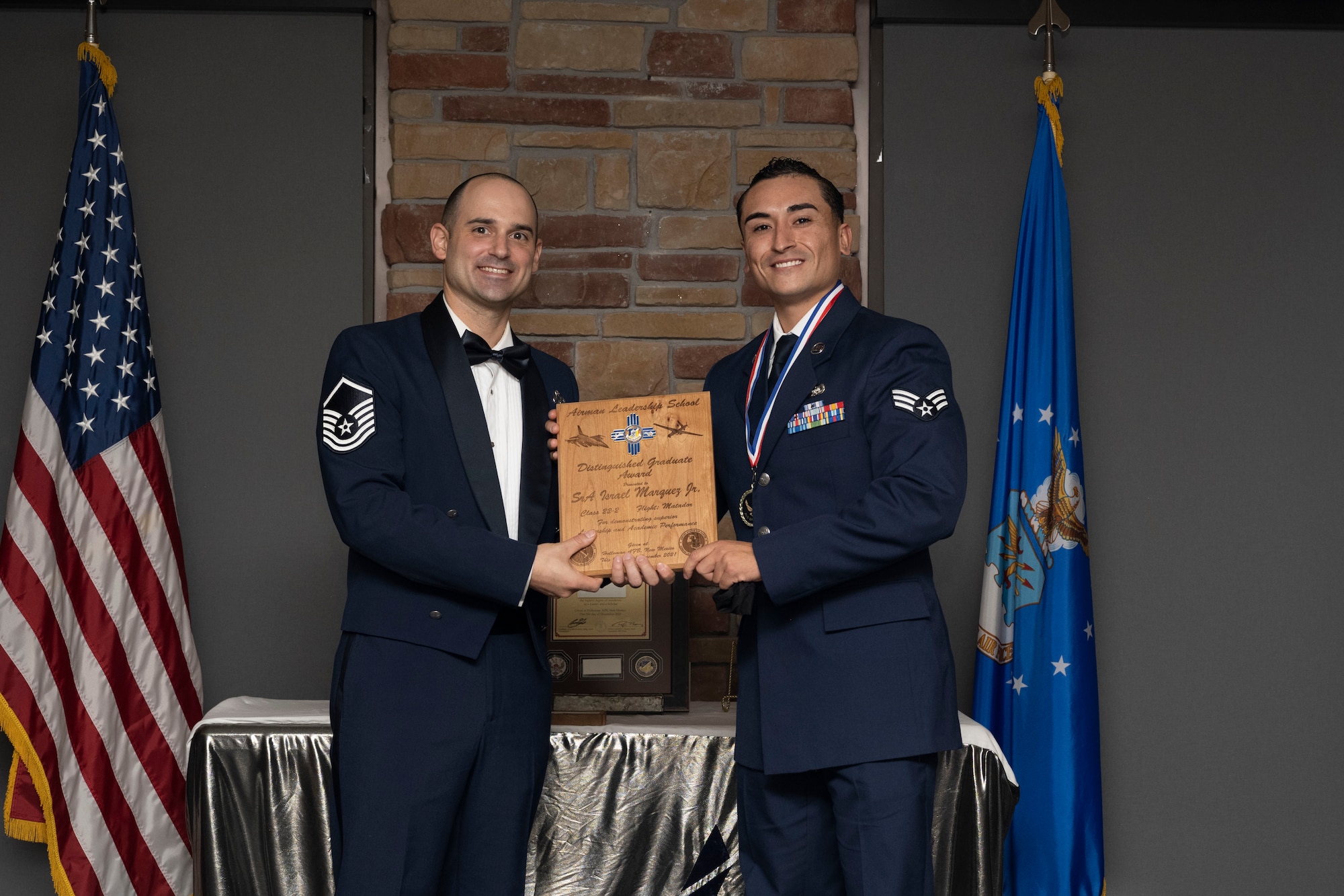 Senior Airman Israel Marquez Jr., Airman Leadership School graduate, accepts the distinguished graduate award during the graduation of ALS class 22-2, Dec. 9, 2021, on Holloman Air Force Base, New Mexico. The distinguished graduate award is presented to the top ten-percent of graduates for their performance in academic evaluations and demonstration of leadership. (U.S. Air Force photo by Senior Airman Kristin Weathersby)