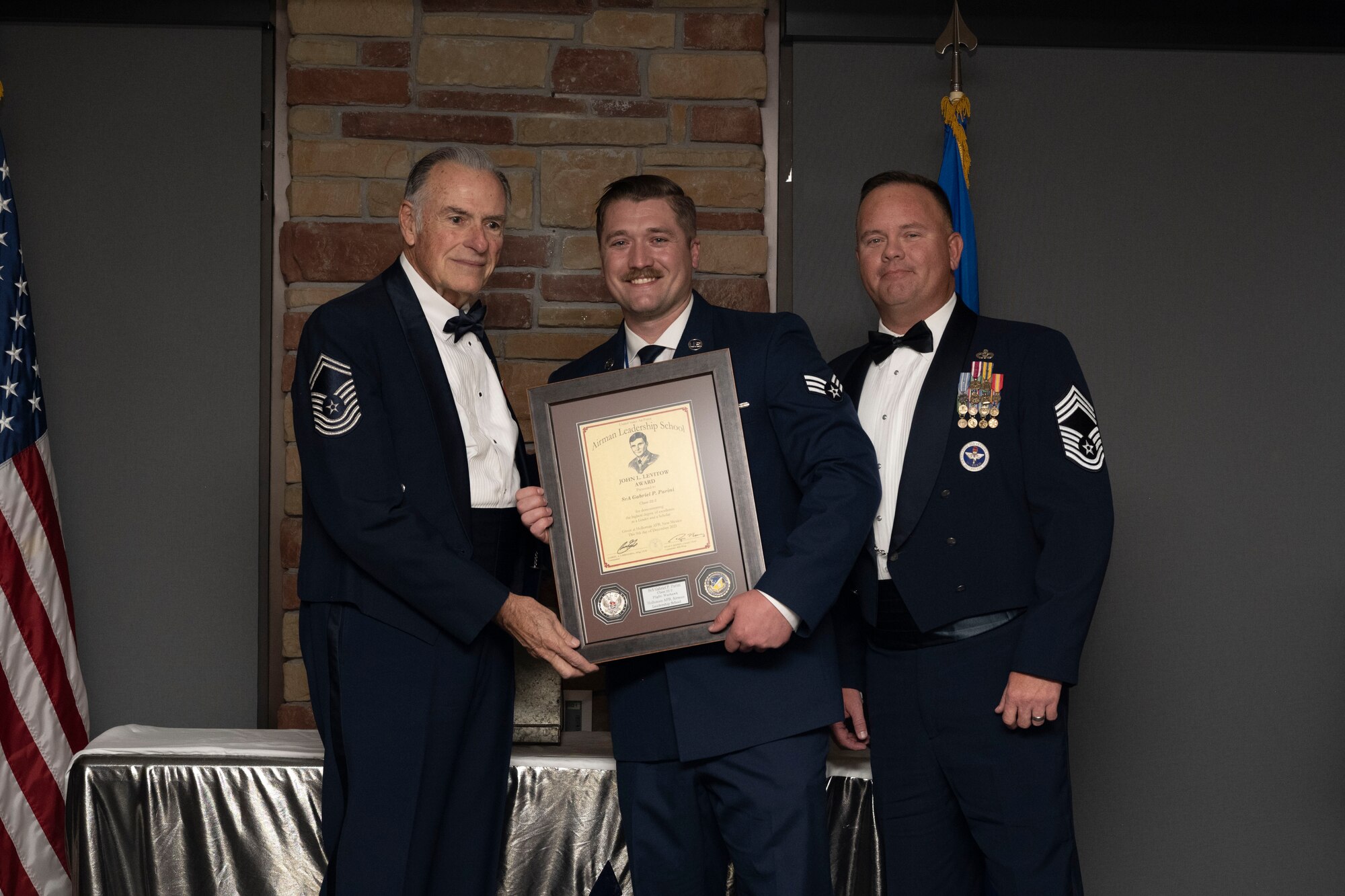 Senior Airman Gabriel P. Parini, Airman Leadership School graduate, accepts the John L. Levitow award during the graduation of ALS class 22-1, Dec. 9, 2021, on Holloman Air Force Base, New Mexico. The John L. Levitow award is presented to the student demonstrating the highest level of leadership and scholastic performance, and is partially determined by the assignment of points by their peers. (U.S. Air Force photo by Senior Airman Kristin Weathersby)