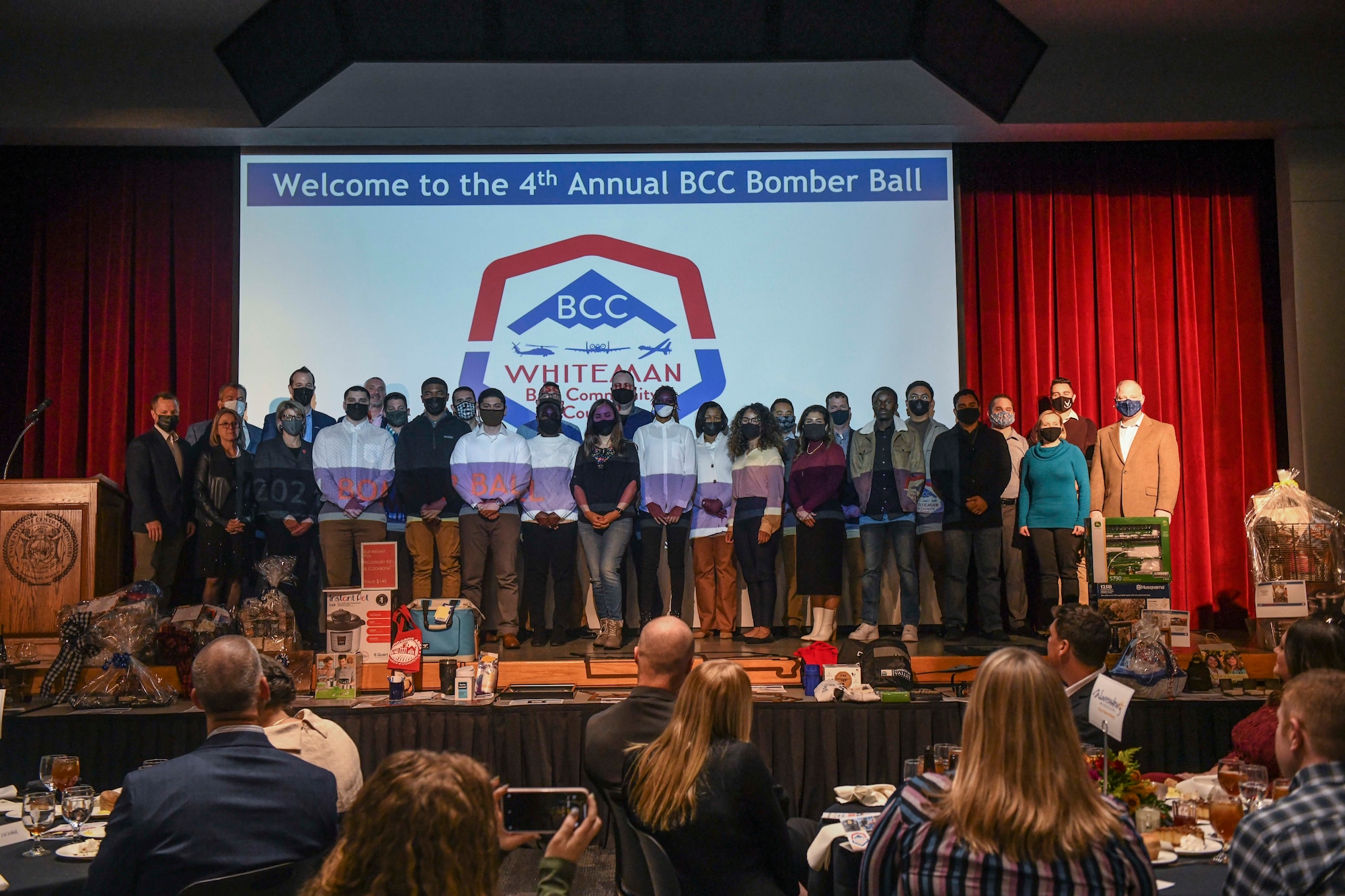 Team Whitman Airmen and their leaders take a group photo during the 4th Annual Bomber Ball at the University of Central Missouri, Warrensburg, Missouri, Nov. 12, 2021. The event celebrated the partnership between Team Whiteman and its 18 partnered communities and included highlighting 18 Airmen whom the Whiteman Base Community Council sent home for the holidays. (U.S. Air Force photo by Staff Sgt. Sadie Colbert)