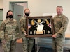 Sgt. 1st Class Roy Tongue is presented a shadow box to congratulate him on a successful tenure as the Headquarters and Headquarters Company, 658th Regional Support Group’s first sergeant following the company’s change of responsibility ceremony December 5th