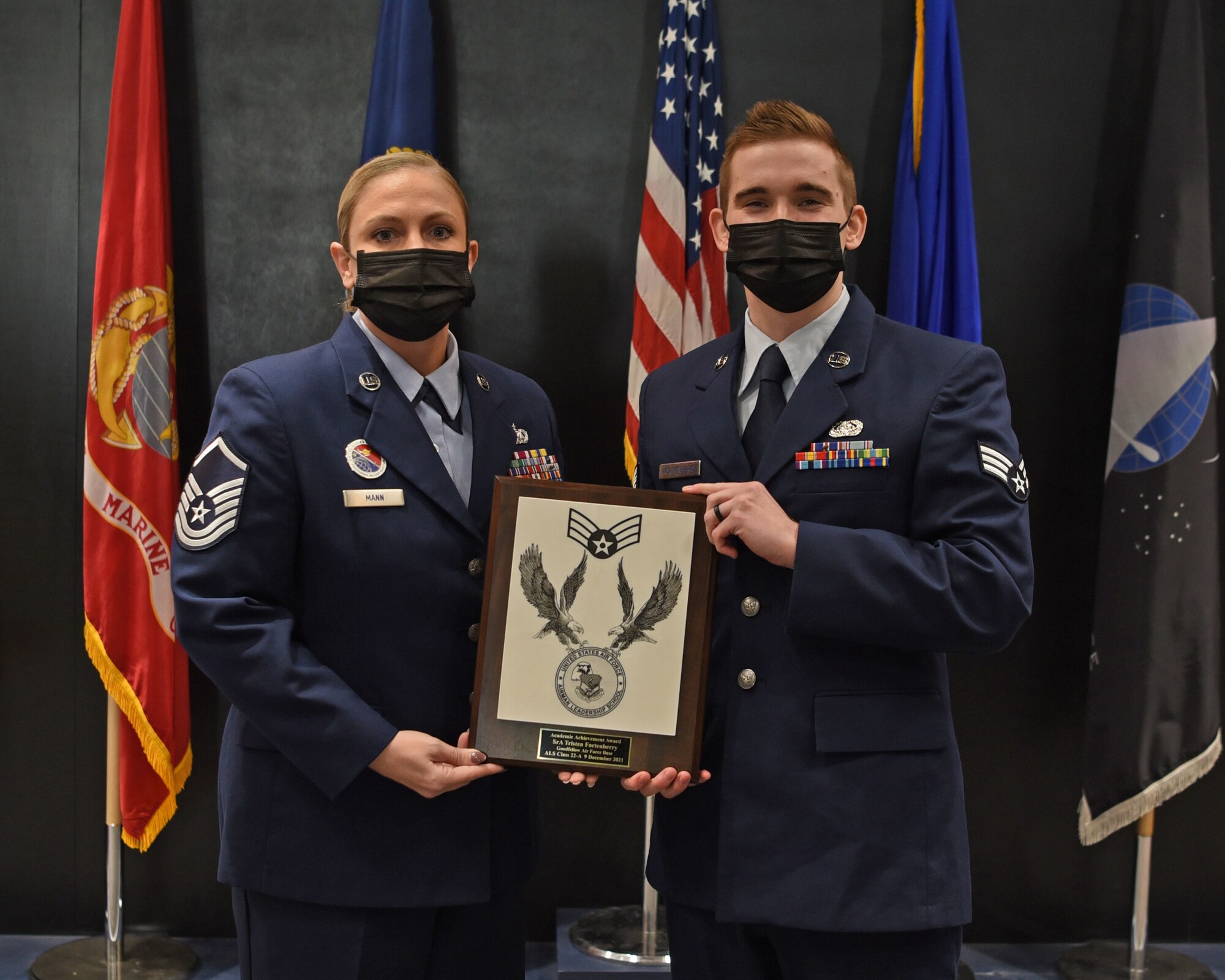 U.S. Air Force Master Sgt. Elizabeth Mann, Goodfellow Airman Leadership School commandant, presents Senior Airman Tristen Fortenberry, 17th Training Support Squadron system administrator, the Academic Achievement Award during Fortenberry’s ALS graduation ceremony on Goodfellow Air Force Base, Texas, Dec. 9, 2021. The Academic Achievement Award recognizes a student who demonstrated academic excellence in all performance tasks and the capstone exercise. (U.S. Air Force photo by Senior Airman Abbey Rieves)