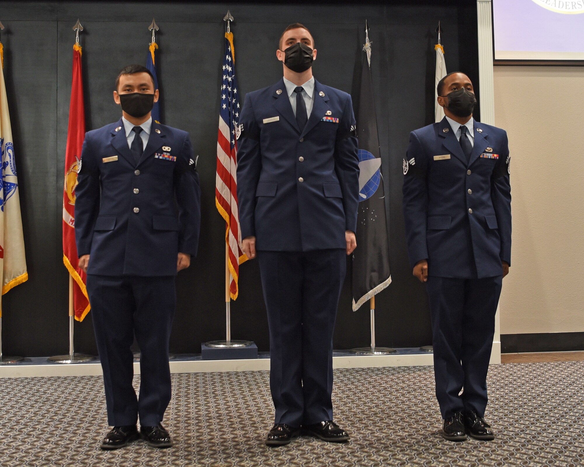 Airman Leadership School Class 22-A graduates and staff sergeant selectees stand at attention while reciting the Non-Commissioned Officer Charge during their ALS graduation ceremony on Goodfellow Air Force Base, Texas, Dec. 9, 2021. The NCO Charge states the additional responsibilities and authorities willingly accepted by every NCO. (U.S. Air Force photo by Senior Airman Abbey Rieves)
