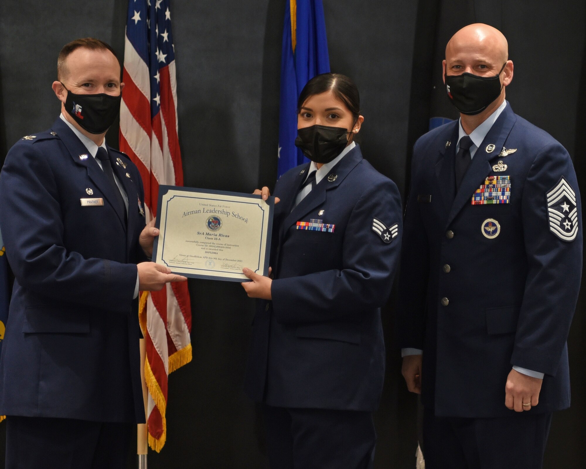 U.S. Air Force Col. Craig Prather, 47th Flying Training Wing commander, and Chief Master Sgt. David Snarr, 47th FTW command chief, present Senior Airman Maria Rivas, 17th Operational Medical Readiness Squadron bioenvironmental engineering technician, is awarded her Airman Leadership School certificate during the ALS graduation ceremony on Goodfellow Air Force Base, Texas, Dec. 9, 2021. ALS Class 22-A focused on developing leadership abilities, the profession of arms, and building effective communication. (U.S. Air Force photo by Senior Airman Abbey Rieves)