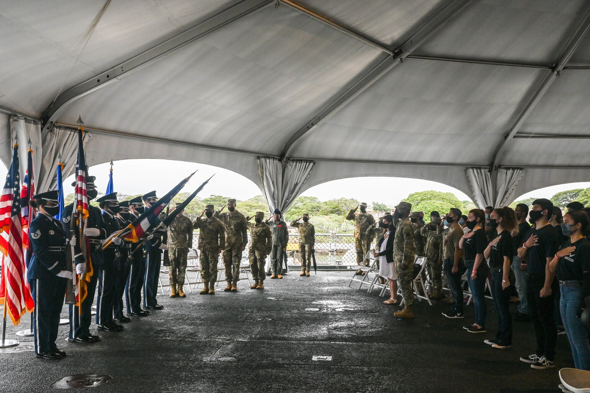 Attendees of a Department of the Air Force total force enlistment ceremony salute and stand at attention during the National Anthem aboard the Battleship Missouri Memorial at Ford Island, Hawaii, Dec. 6, 2021. A group of 20 recruits swore into service, representing Air Force guard, reserve, active-duty and Space Force. (U.S. Air Force photo by Staff Sgt. Alan Ricker)