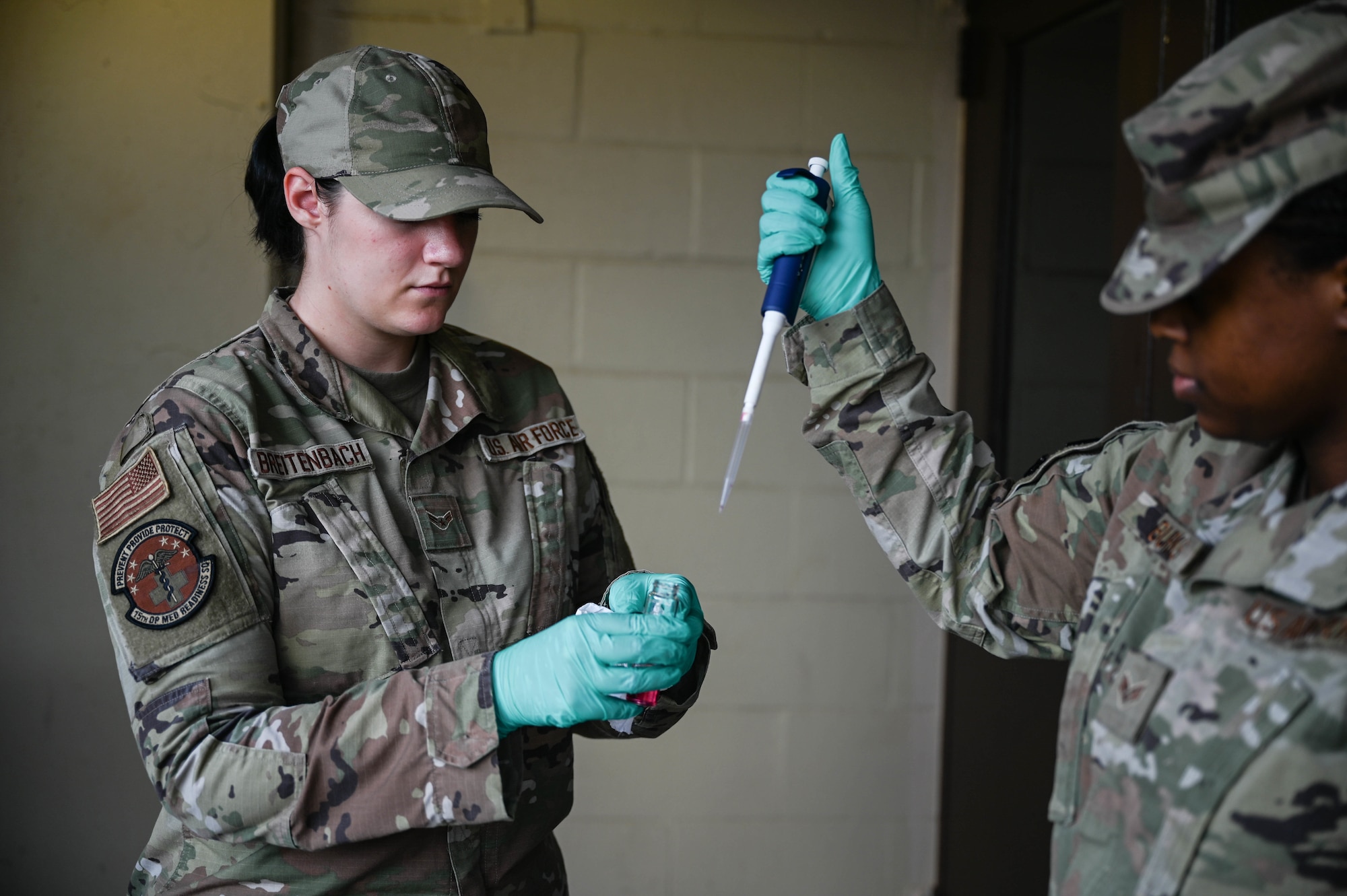 Airman 1st Class Sydni Breitenbach and Senior Airman Christina Burks, 15th Operational Medical Readiness Squadron bioenvironmental engineering journeymen, perform a pH test of a water sample taken from a Potable Water Module at the Hale Aina Dining Facility at Joint Base Pearl Harbor-Hickam, Hawaii, Dec. 10, 2021. The bioenvironmental team conducted pH tests, free chlorine tests and volatile organic compound screenings at several different Air Force sites on JBPHH to support the Navy’s sampling effort and plans to continue to test 17 various sites. (U.S. Air Force photo by Staff Sgt. Alan Ricker)