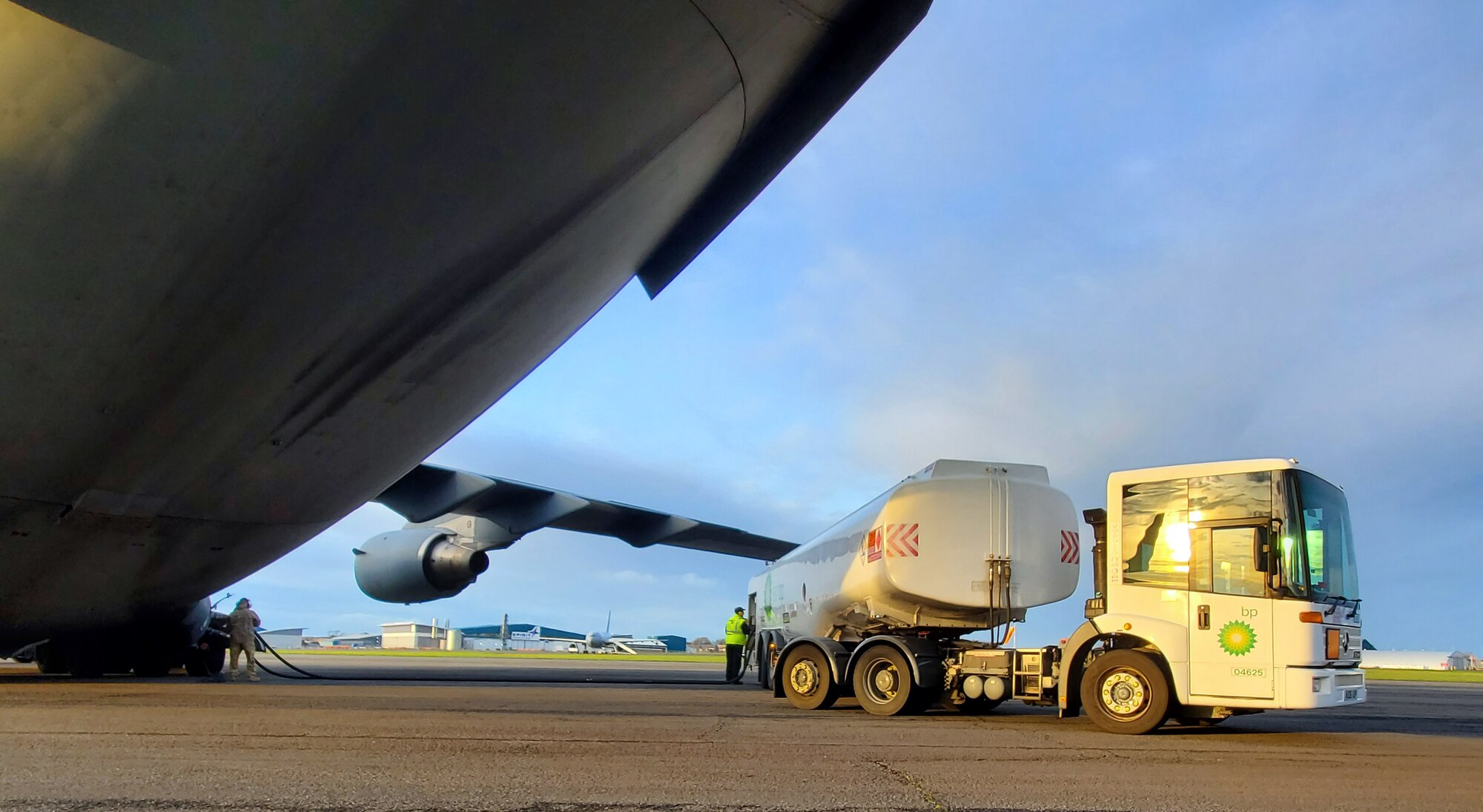 Workers at Glasgow Prestwick Airport, Scotland, refuel a C-17 Globemaster III assigned to Joint Base Lewis-McChord, Washington, at the airport Dec. 2, 2021. Airmen assigned to the 62nd Airlift Wing flew the C-17 to and from Al Udeid Air Base, Qatar, to transport deploying Airmen and bring home those whose deployment had ended. (U.S. Air Force photo by Staff Sgt. Tryphena Mayhugh)