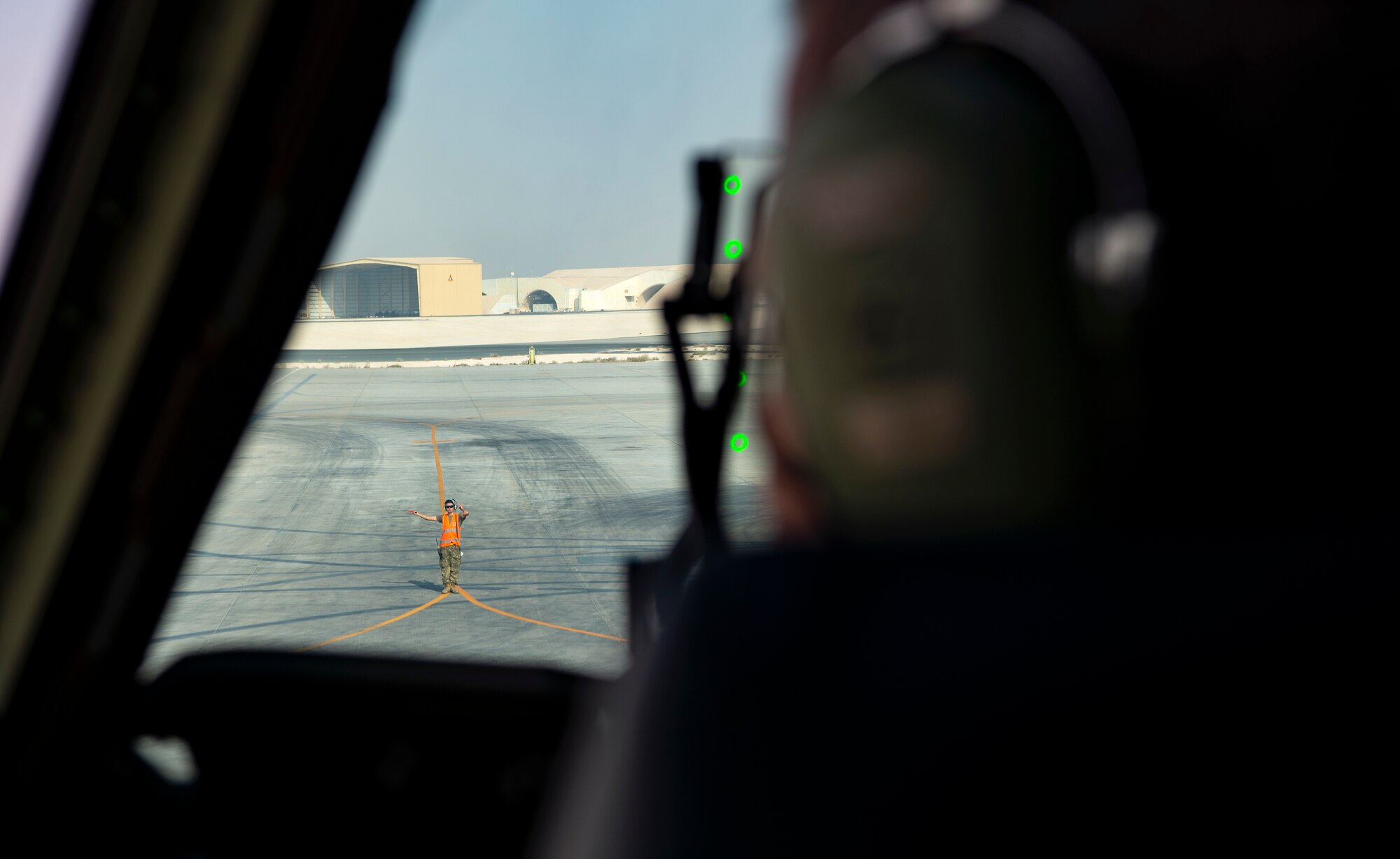 A U.S. Airmen assigned to Al Udeid Air Base, Qatar, left, marshals U.S. Air Force Col. Brian Collins, 62nd Airlift Wing vice commander, to pilot a C-17 Globemaster III out of its parking space at Al Udeid, Dec. 1, 2021. Collins and other 62nd AW Airmen participated in the EAS (Expeditionary Airlift Squadron) Swap Out to deliver deploying Airmen to the 816th EAS at Qatar and bring home those whose deployment had ended. (U.S. Air Force photo by Staff Sgt. Tryphena Mayhugh)