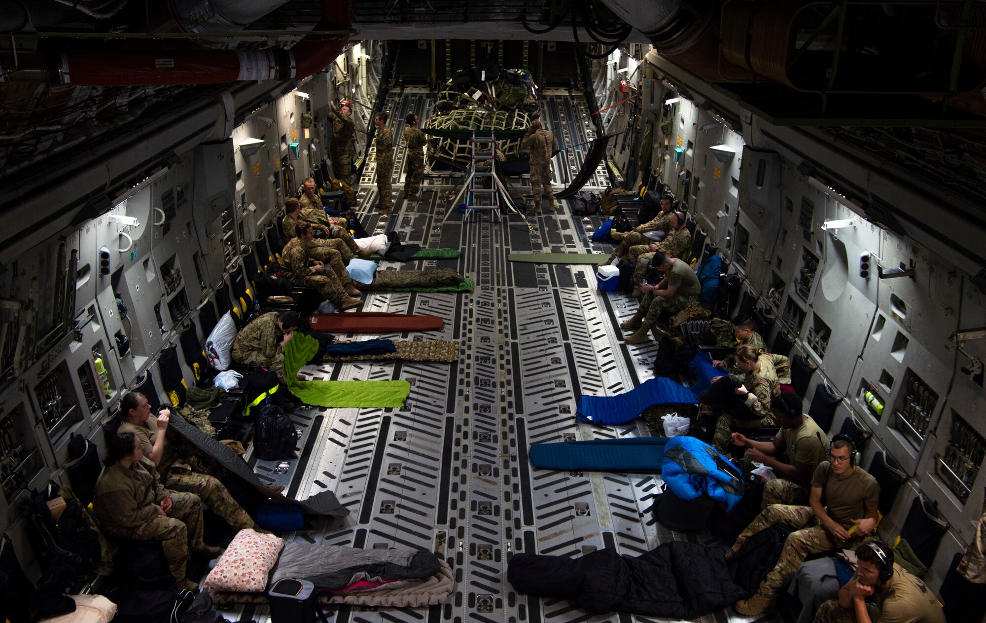 U.S. Airmen assigned to Joint Base Lewis-McChord, Washington; Joint Base McGuire-Dix-Lakehurst, New Jersey; and Dover Air Force Base, Delaware, prepare to sleep on a C-17 Globemaster III before taking off from Al Udeid Air Base, Qatar, Dec. 1, 2021. The Airmen are returning home after having been deployed to the 816th Expeditionary Airlift Squadron. (U.S. Air Force photo by Staff Sgt. Tryphena Mayhugh)