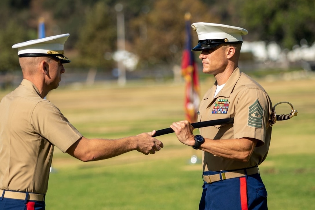 U.S. Marine Corps Sgt. Maj. Nicholas J. Purtell, right, the oncoming Sergeant Major for Recruiting Station Los Angeles, prepares to hand of the Non-Commissioned Officer Sword to Maj. Cole Lapierre, the Commanding Officer for Recruiting Station Los Angeles, during a relief and appointment ceremony at the Rose Bowl Stadium in Pasadena, California, Sept. 10, 2021. The relief and appointment ceremony acknowledges the efforts put into the unit by Sgt. Maj. Carlos Weiss during his time as the Recruiting Station Sergeant Major as well as welcomes Sgt. Maj. Purtell into the unit. (U.S. Marine Corps photo by Staff Sgt. Antonio R. Campbell)